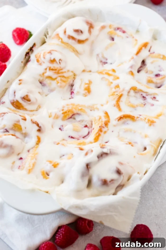 Effortless Raspberry Sweet Rolls 4 A photo of a pan of easy berry sweet bread covered in frosting.