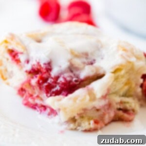 Effortless Raspberry Sweet Rolls 9 Freshly baked Raspberry Sweet Rolls with a generous layer of glaze, ready to be served.