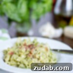 2012's Flavorful Favorites 14 Quick 15-Minute Pesto Pasta with crumbled speck, showing fresh pasta coated in green pesto.