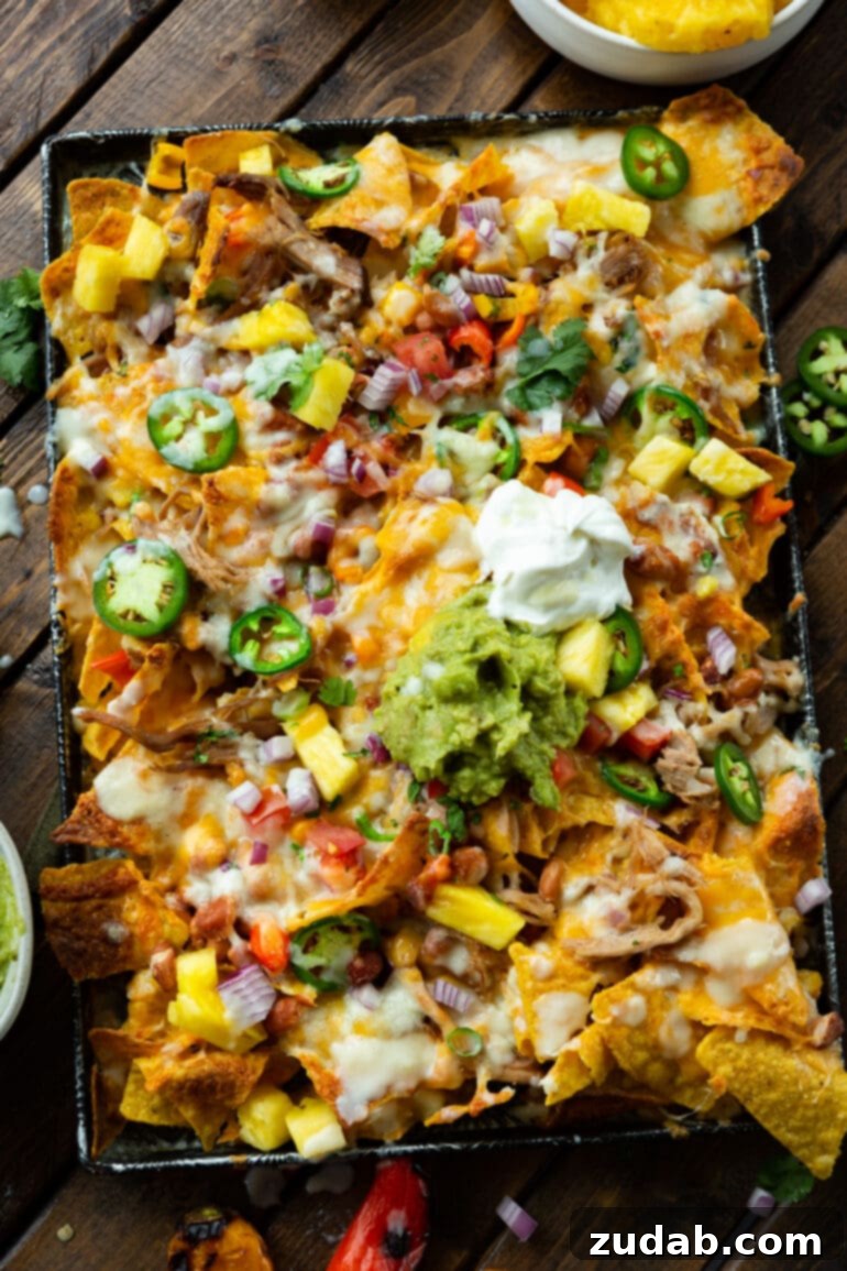 Crockpot Luau Pulled Pork Nachos 4 A visually appealing photo of a sheet pan fully loaded with rich, cheesy Hawaiian pulled pork nachos, ready to be devoured!