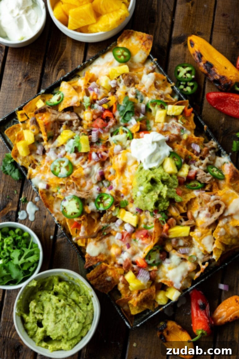 Crockpot Luau Pulled Pork Nachos 5 An overhead shot showcasing a delectable sheet pan overflowing with Hawaiian pulled pork nachos, generously drizzled with the signature pina colada sauce.