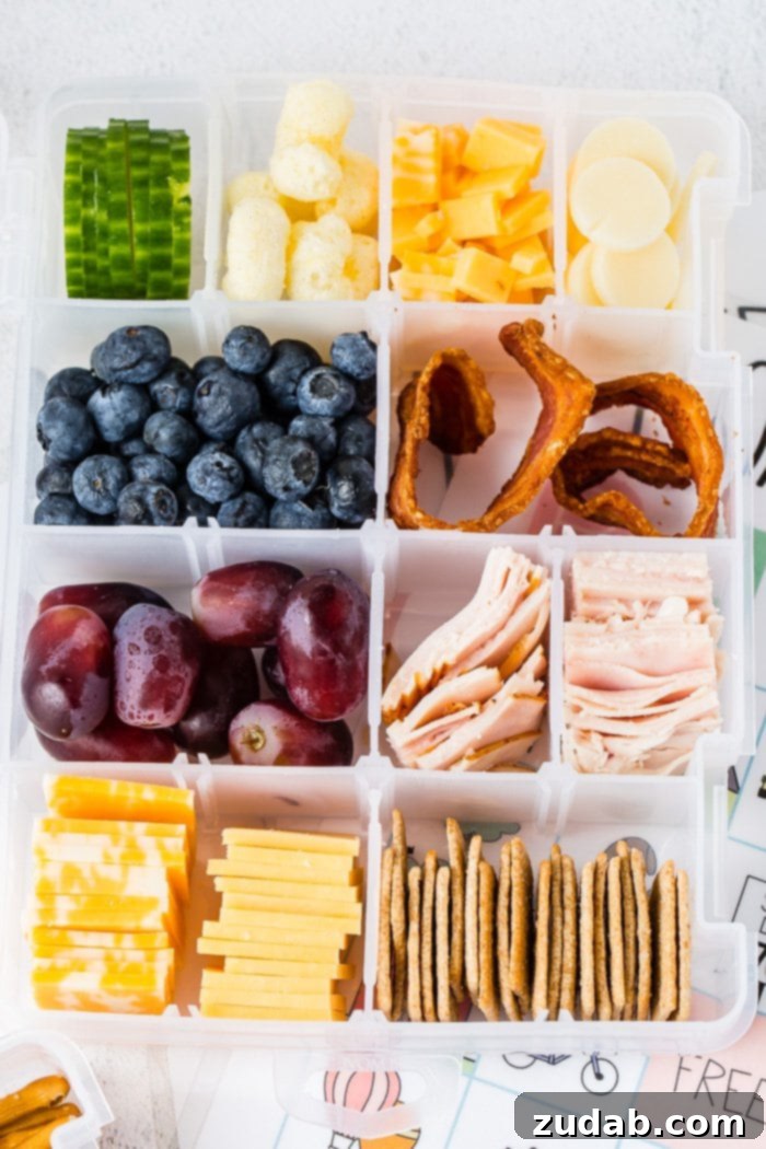 Road Trip Ready Snacks and Entertainment Solutions 2 A craft box typically used for beads or other crafts is cleverly repurposed and filled with an assortment of healthy snacks. This includes various nuts, fresh fruits, miniature sandwiches, slices of cheese, and wholesome crackers, offering a perfect healthy road trip snack box solution for families.