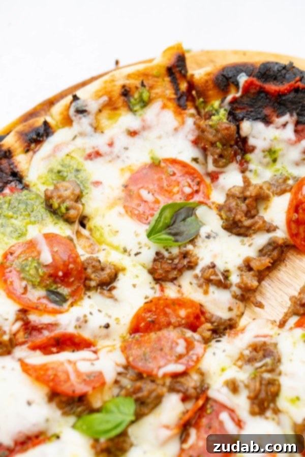 Pesto Pepperoni Grilled Pizza - Oh Sweet Basil A photo of a piece of pesto pepperoni grilled pizza.