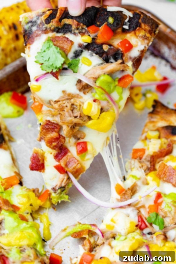 Pulled Pork Pizza with Sweet Corn and Cilantro Cream A photo of pulled pork pizza covered in sweet corn, red onions, pinapple, bacon, and fresh cilantro.