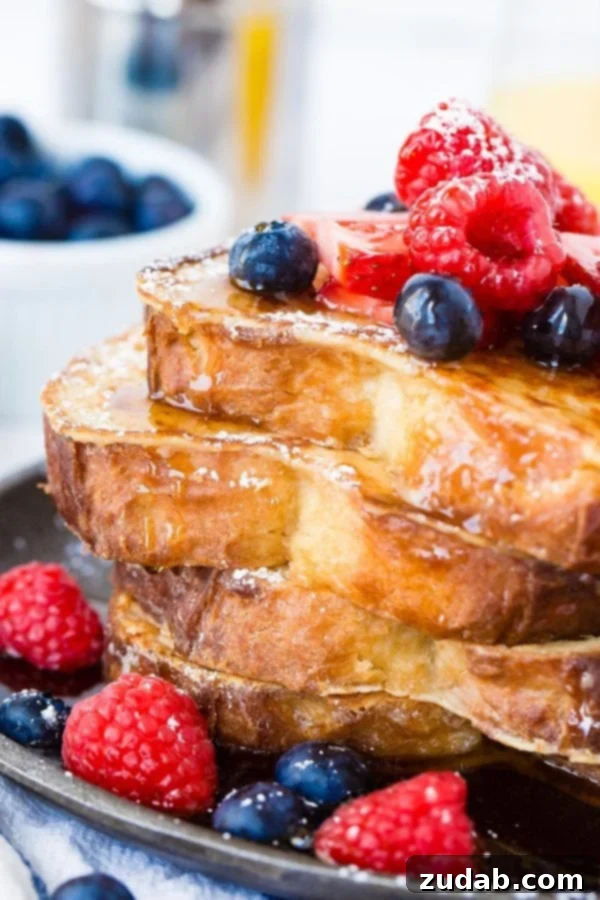 How to Make French Toast A photo of a stack of 4 perfectly made french toast slices dripping with syrup and fresh berries. How to Make French Toast