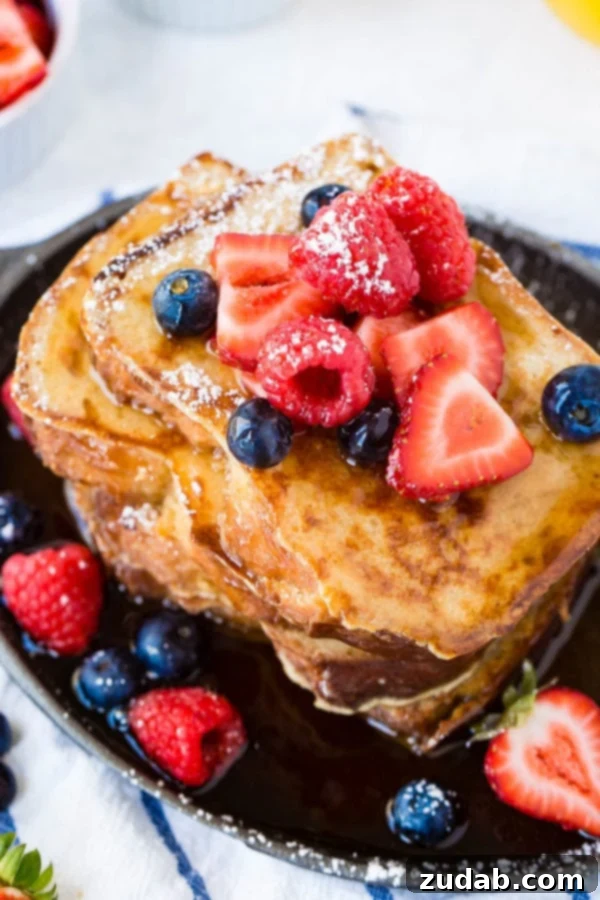 How to Make French Toast A photo of a stack of french toast covered in dripping syrup and fresh berries.
