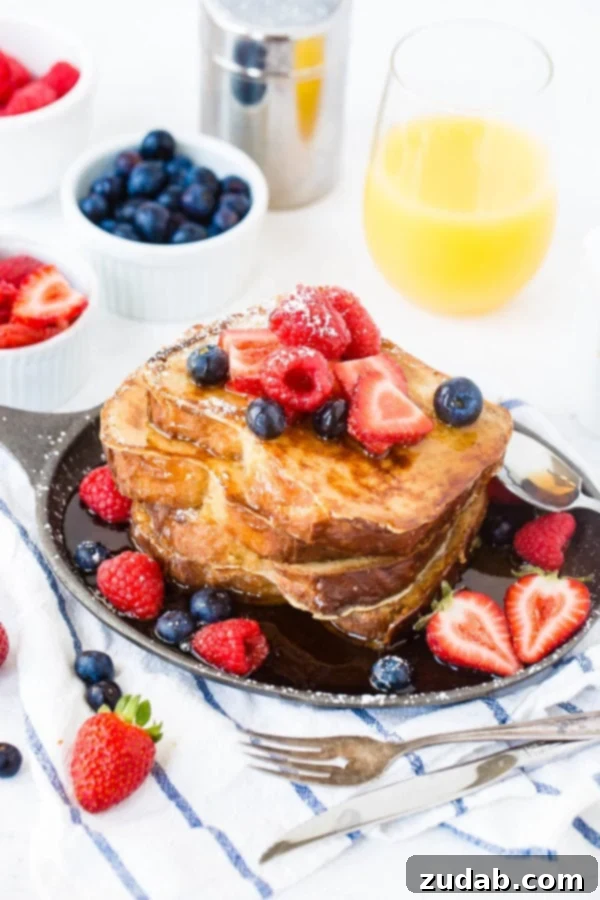How to Make French Toast A photo of a stack of french toast covered in dripping syrup and fresh berries.