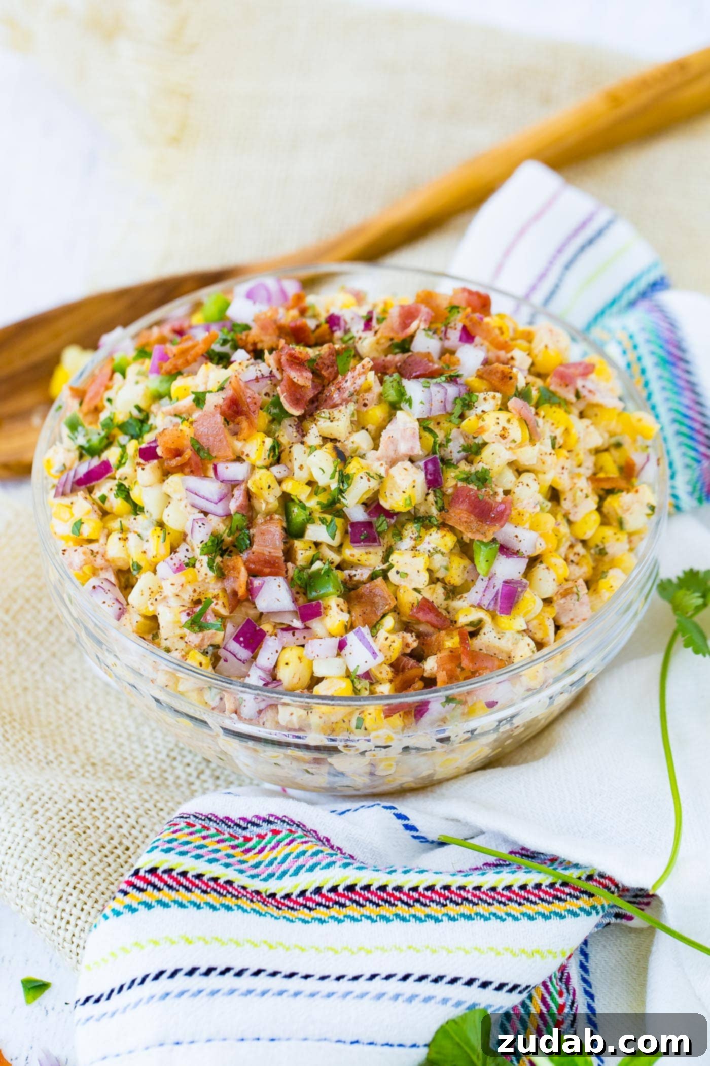 Jalapeno Bacon Eloted Mexican Grilled Corn Salad A bowl of Mexican corn salad topped with bacon and jalapeno, perfect for a summer gathering.