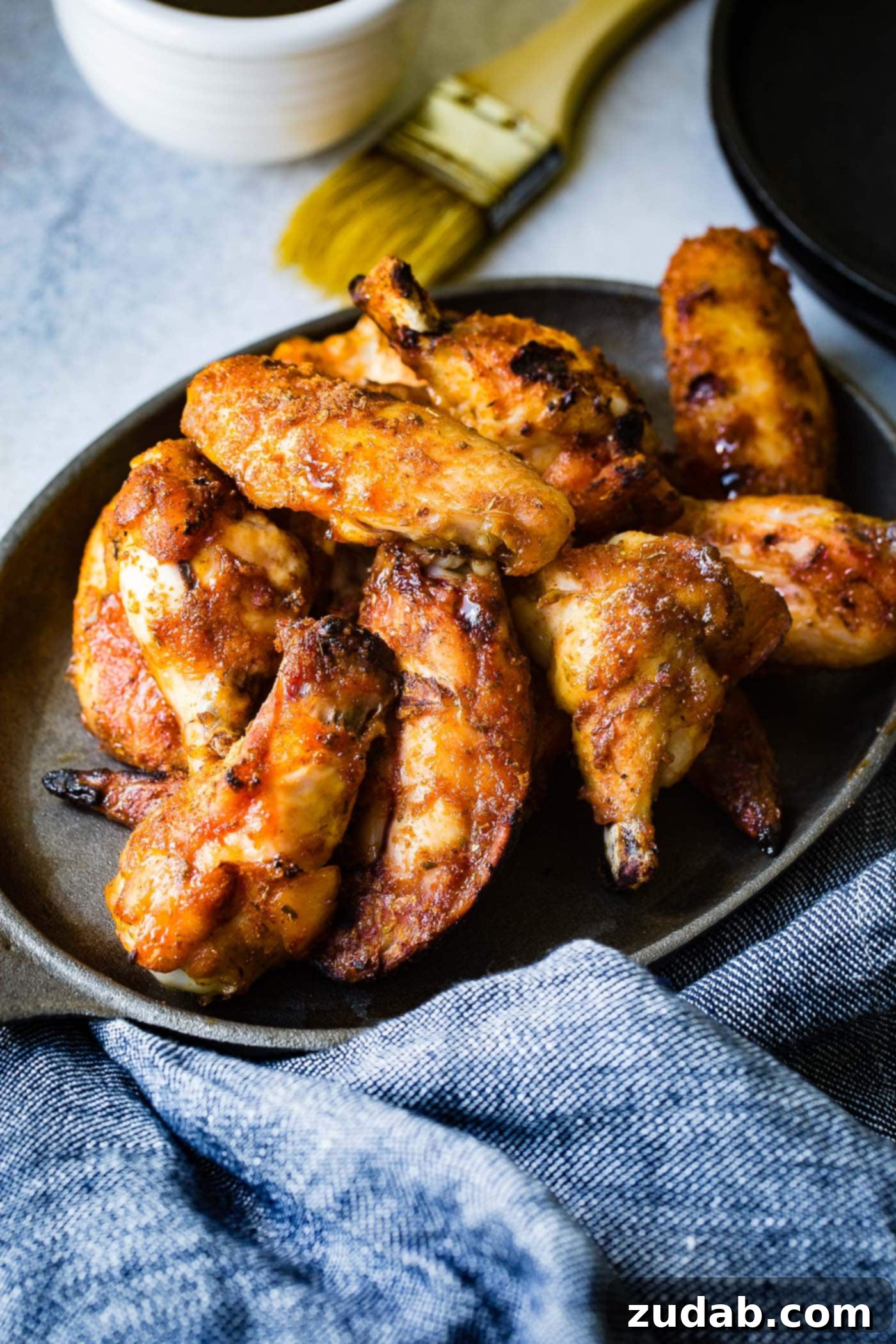 The BEST Dry Rubbed Smoked Chicken Wings A photo of a plate full of dry rubbed smoked chicken wings, garnished and ready to serve.