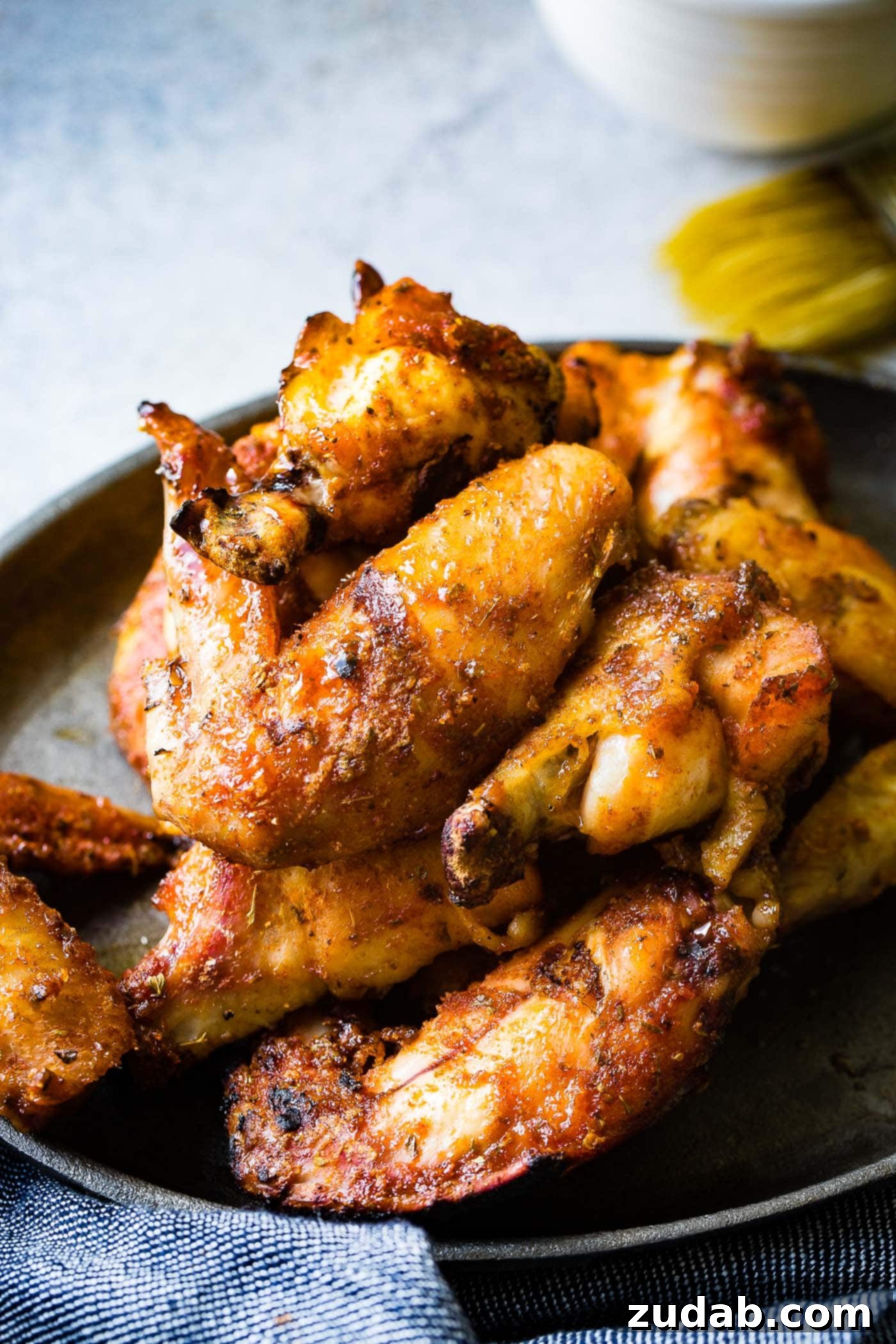 The BEST Dry Rubbed Smoked Chicken Wings A photo of a plate full of smoked poultry, showcasing the delicious dry rub and crispy skin.