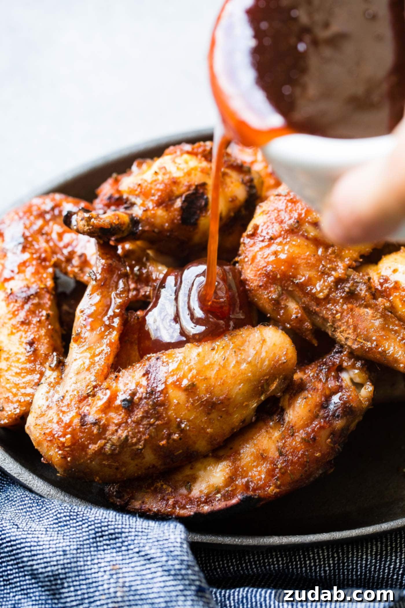 Glazed Smoked Chicken Wings A photo of a sweet glaze being poured on smoked chicken wings.