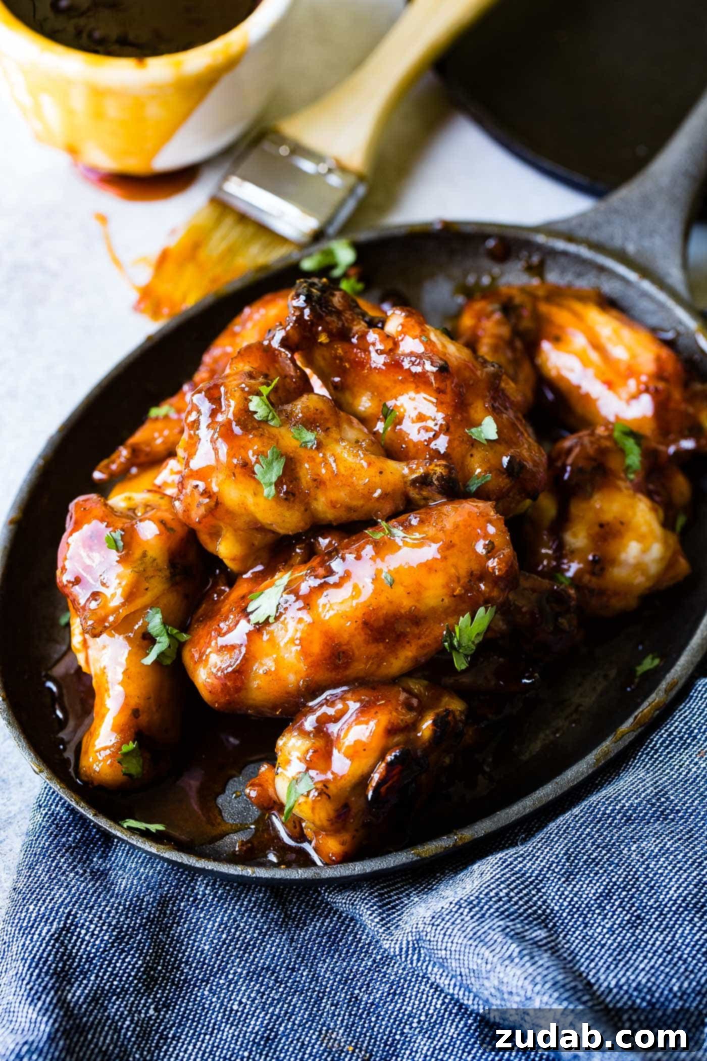 Glazed Smoked Chicken Wings A photo of a plate full of glazed smoked chicken wings topped with chopped cilantro.