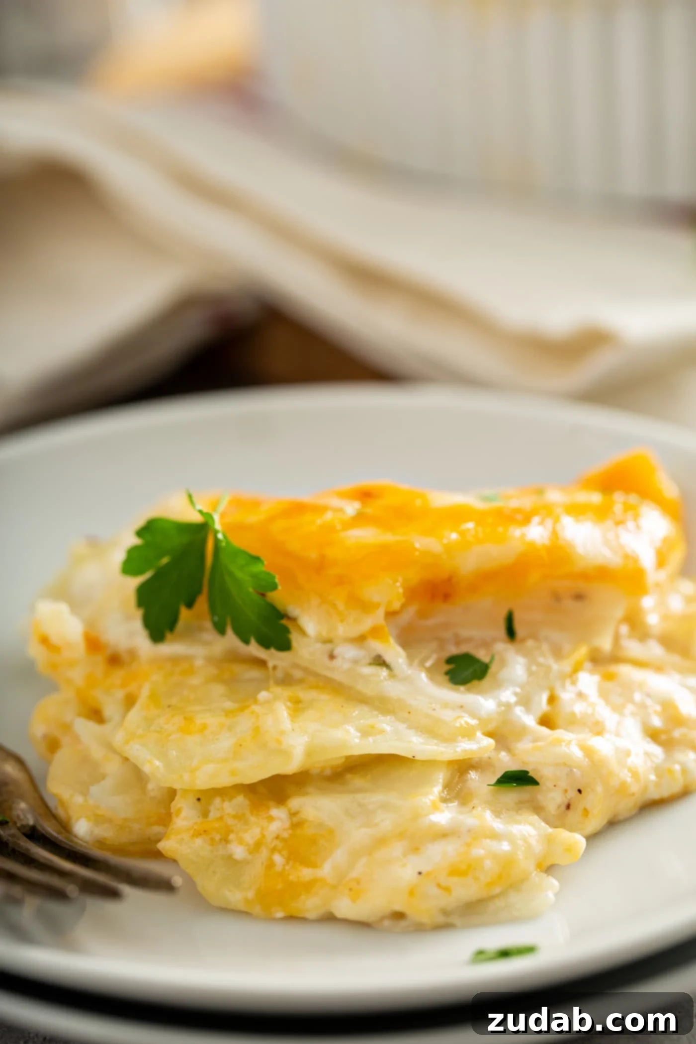Simple Instant Pot Potatoes A plate of instant pot cheesy potatoes. The cheese is melted and the potatoes are creamy. It is topped with a parsley leaf.