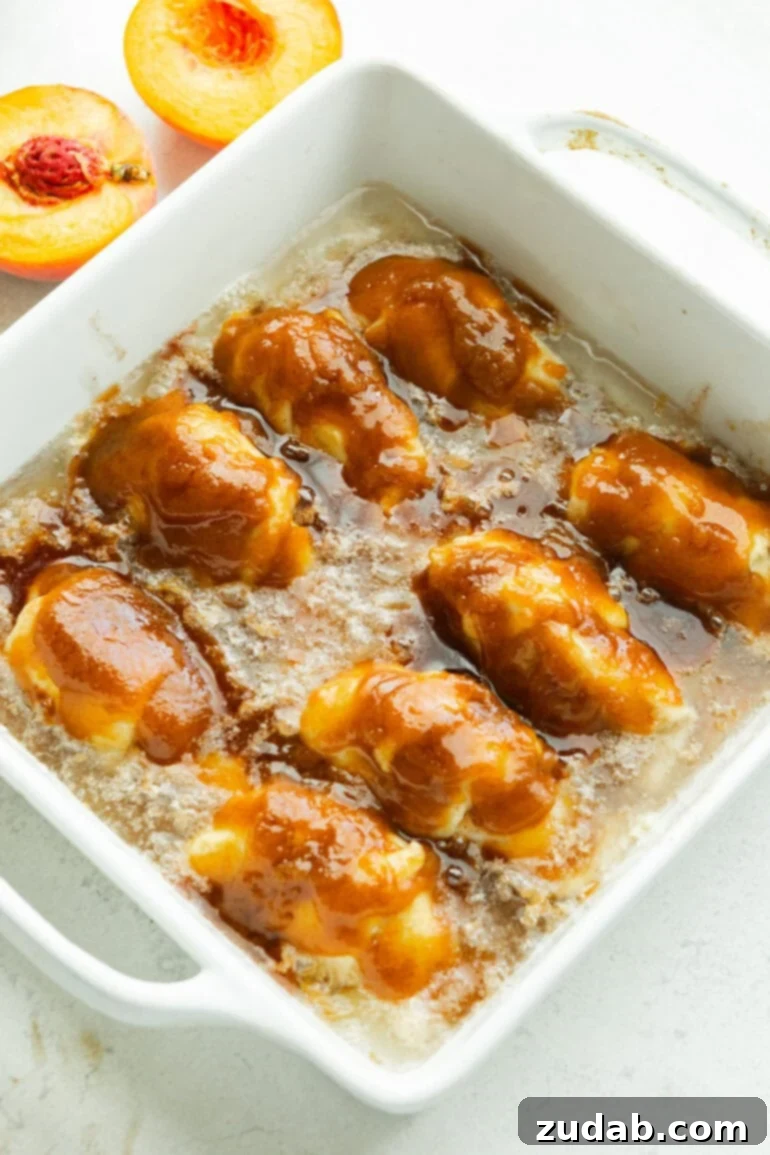 Crescent Roll Peach Dumplings with a Sprite Twist 4 a square baking dish full of baked saucy golden peach dumplings sitting in a caramel sauce