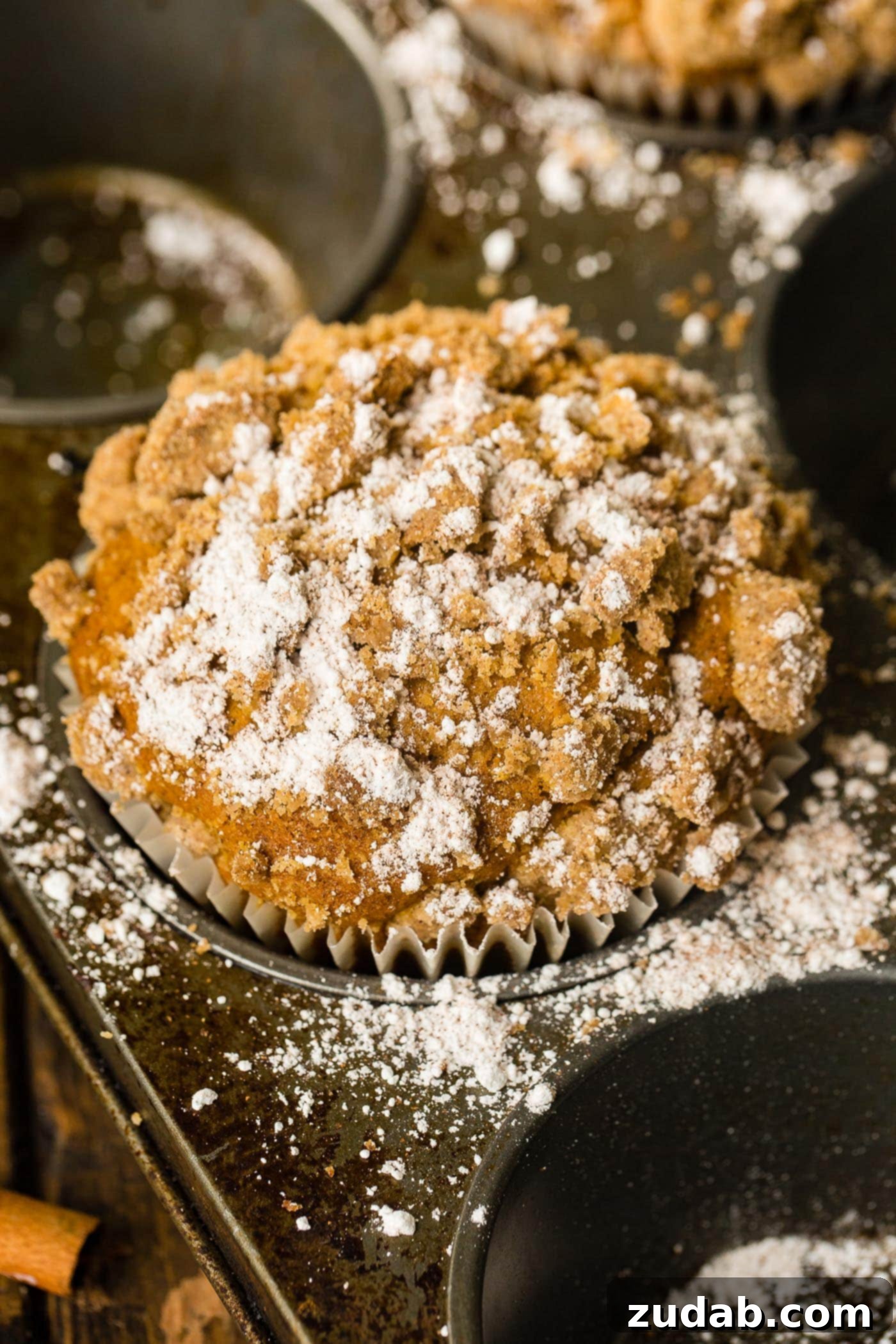 Irresistible Costco Style Pumpkin Streusel Muffins 4 Another enticing shot of a jumbo pumpkin streusel muffin with a light dusting of powdered sugar.