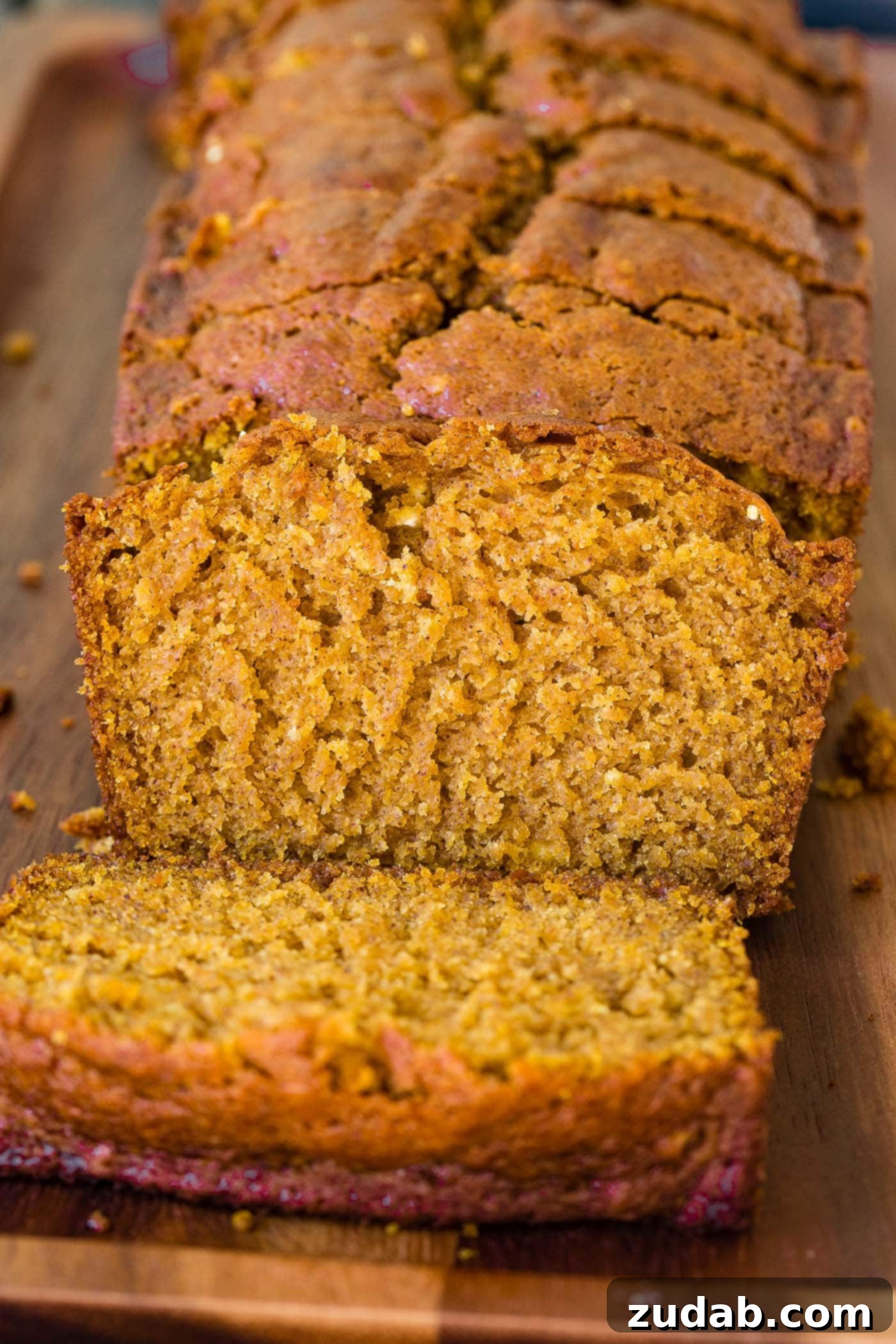 The Best Moist Pumpkin Bread Recipe A perfectly sliced loaf of pumpkin bread on a rustic wooden platter, ready to be enjoyed.