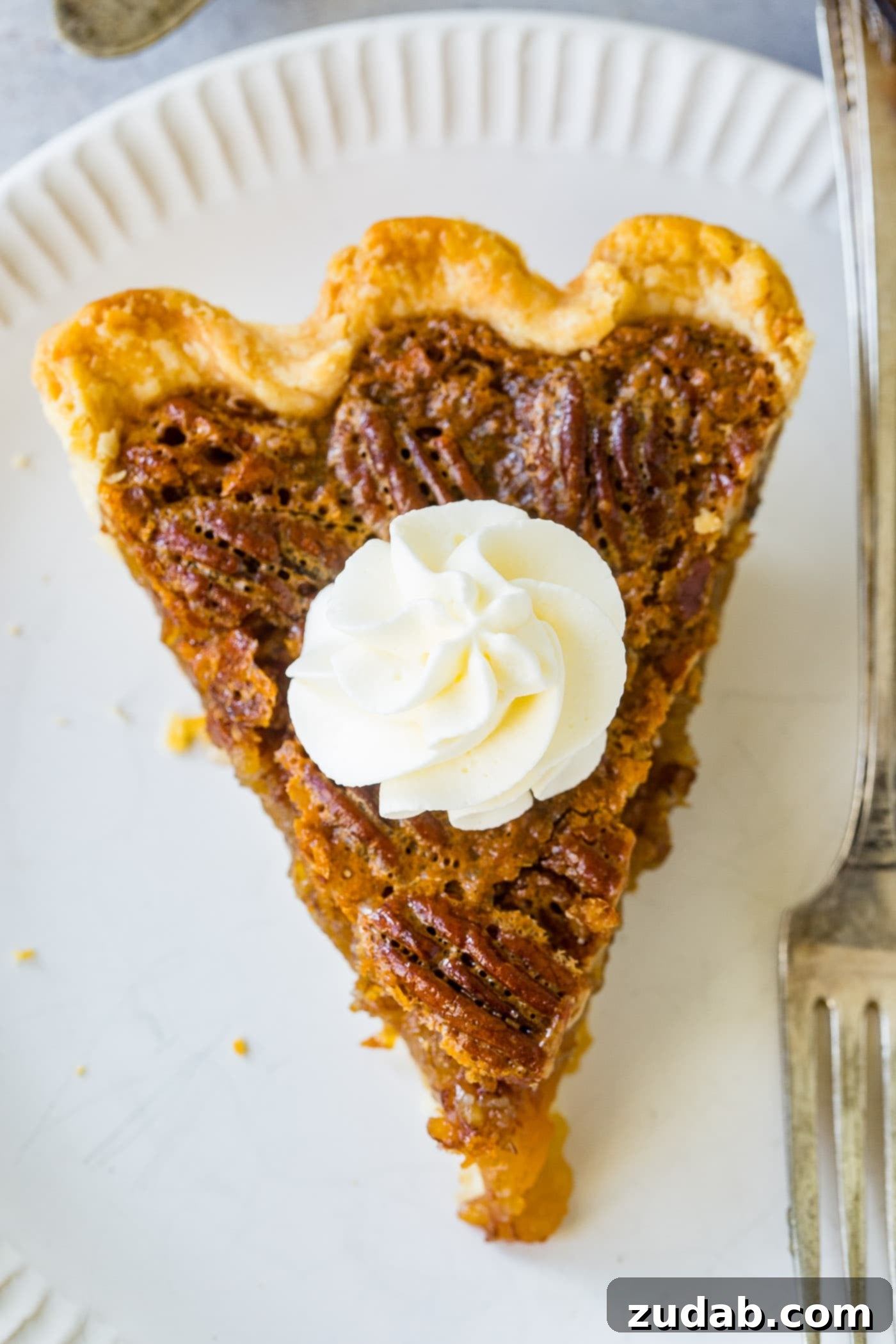 A photo of a slice of pecan pie taken from overhead.