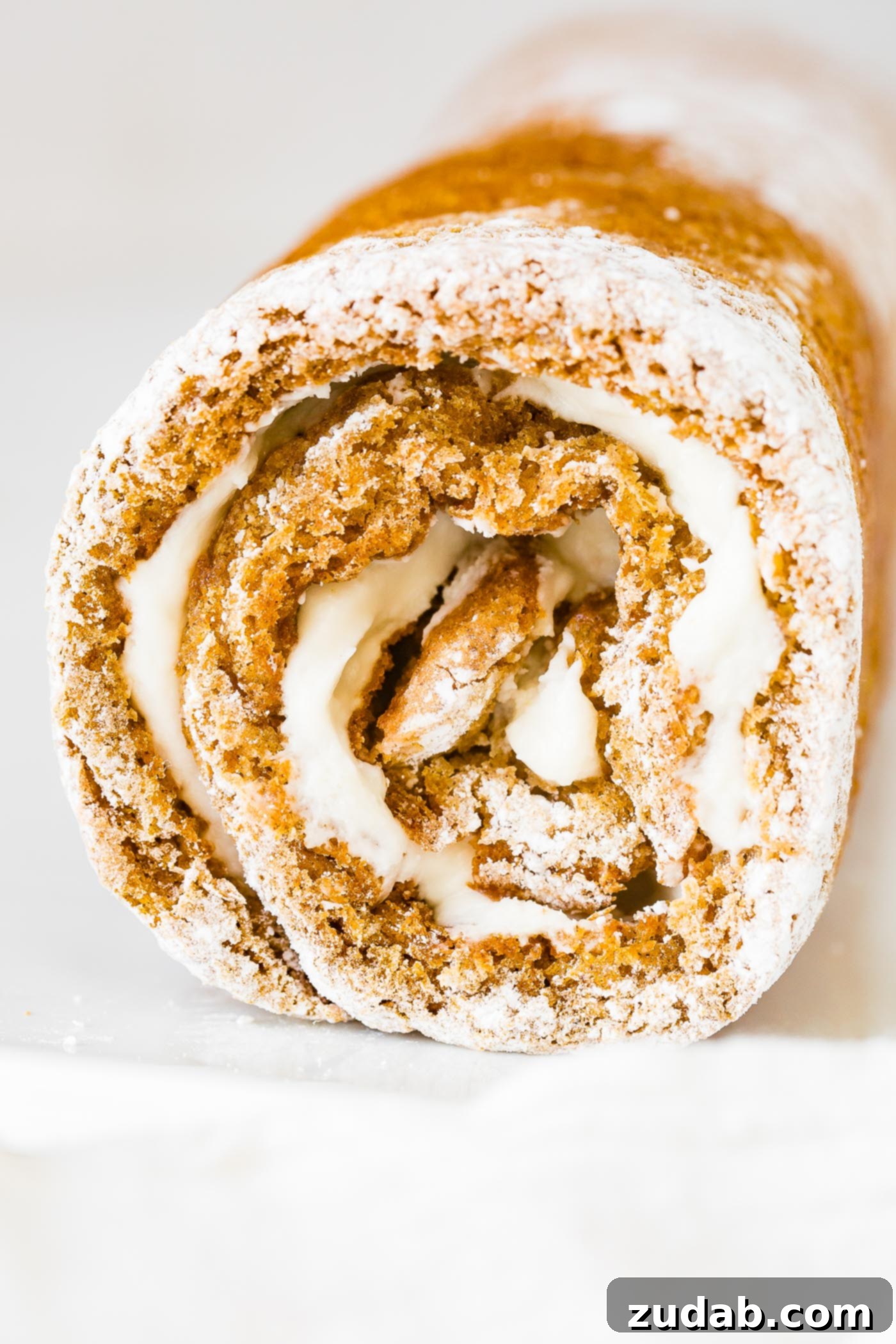 Better Than Libby's Pumpkin Roll Recipe A photo of a pumpkin roll that has just been rolled and is cooling, ready for the filling.