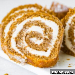 Your New Favorite Pumpkin Roll Recipe 2 A beautifully sliced pumpkin roll with cream cheese filling, ready to serve.