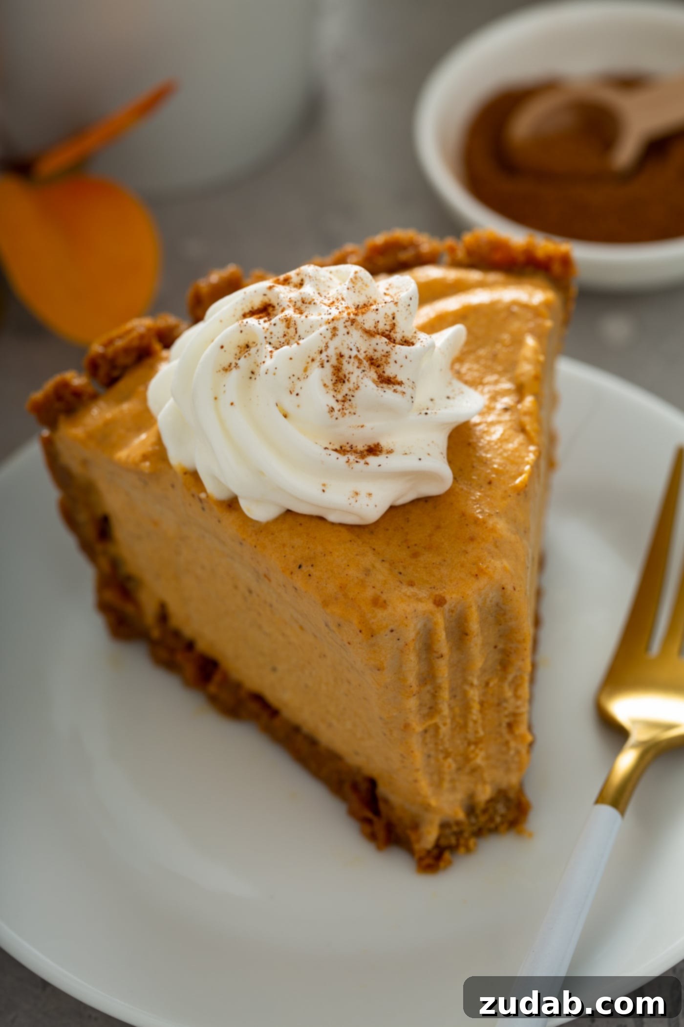A delectable slice of pumpkin ice cream pie with a fork poised beside it, showcasing a perfect bite already taken. The pie is elegantly topped with a dollop of whipped cream, dusted lightly with cinnamon, highlighting its rich and inviting texture.