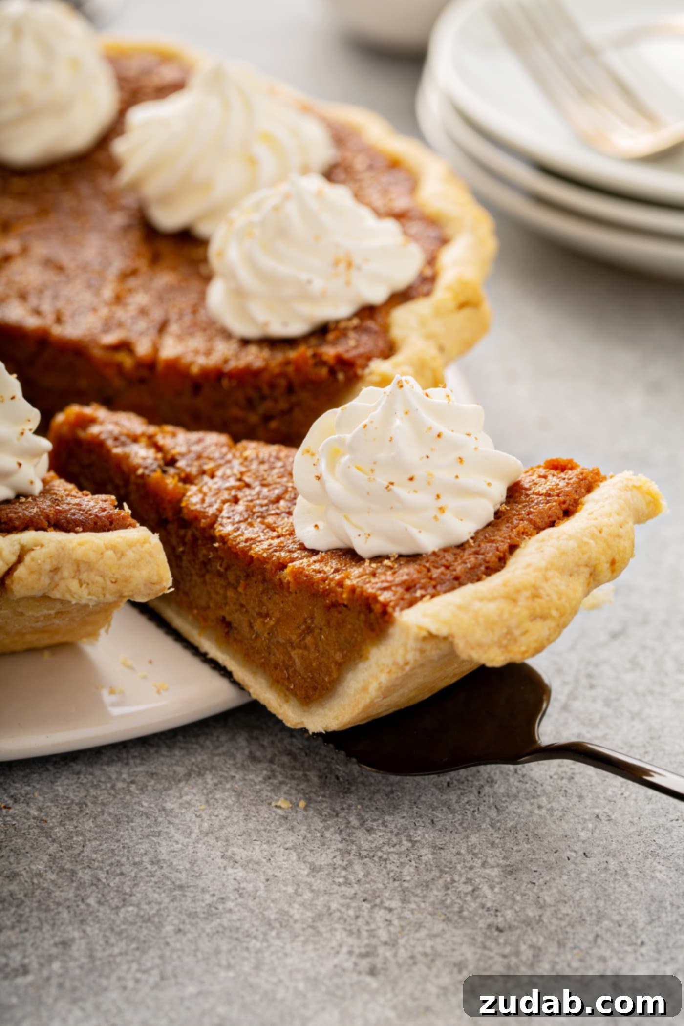 Perfectly Southern Sweet Potato Pie A photo of a slice of sweet potato pie being removed from a whole pie.