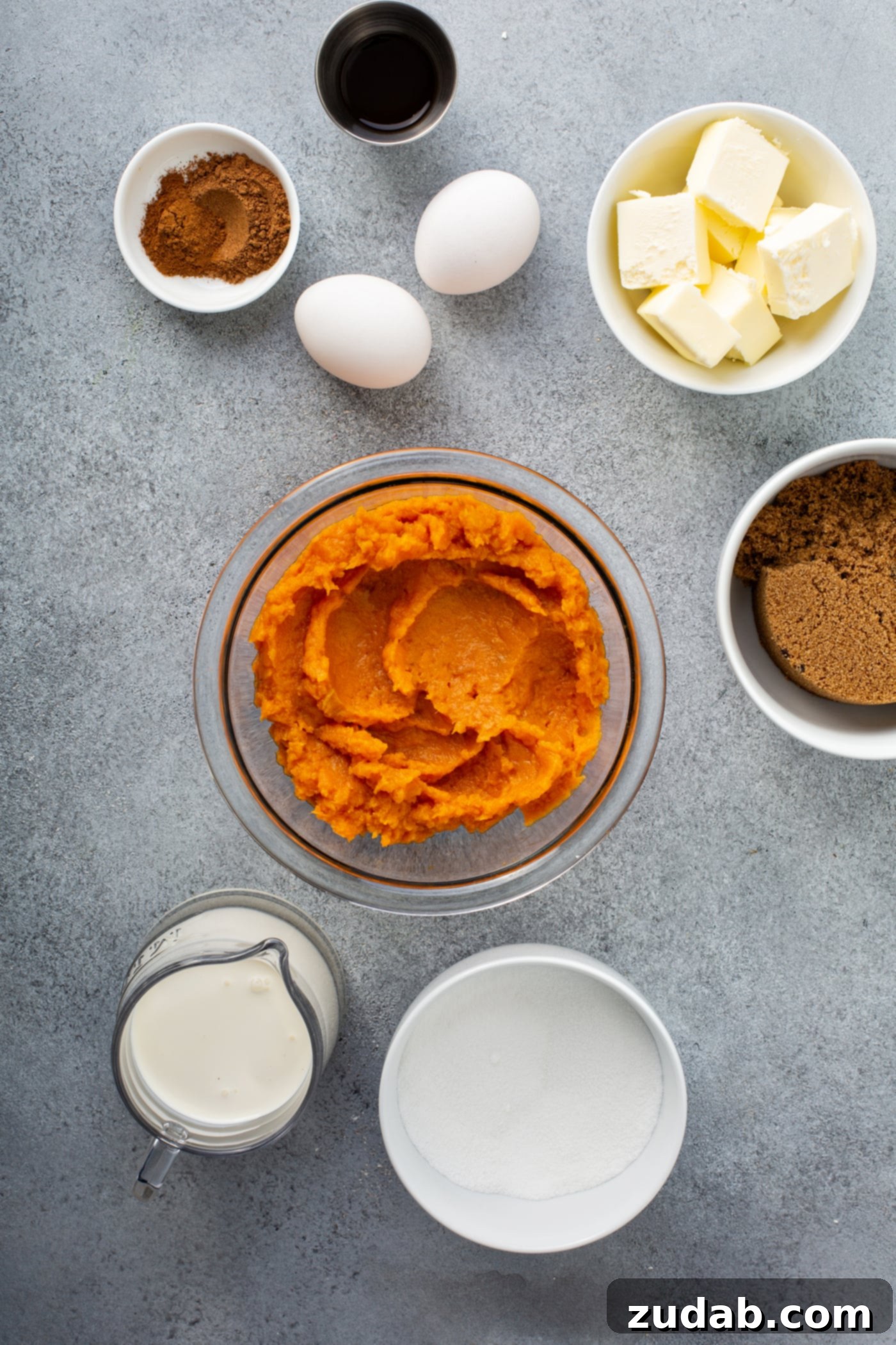 Perfectly Southern Sweet Potato Pie A photo of all the ingredients for sweet potato pie in separate bowls - pureed sweet potatoes, dark brown sugar, butter, two eggs, vanilla, sugar, cream, and cinnamon.