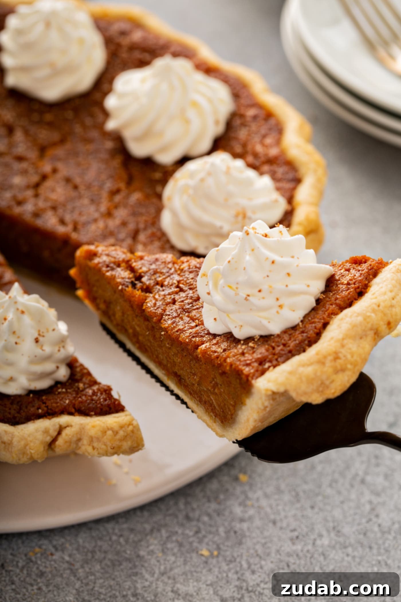 Perfectly Southern Sweet Potato Pie A photo of a slice of sweet potato pie being removed from a whole pie.
