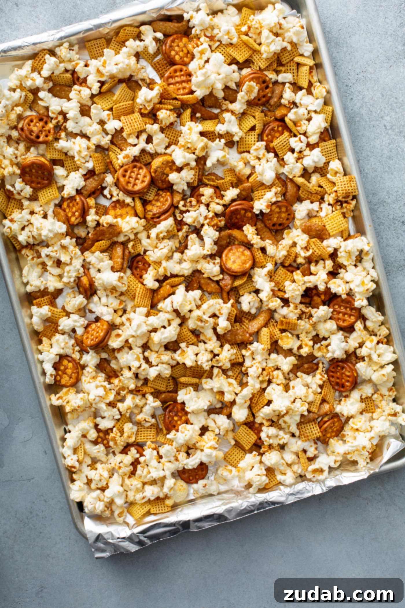 March Madness Snack Mix A baking sheet filled with popcorn, chex, pretzels, and sesame sticks.