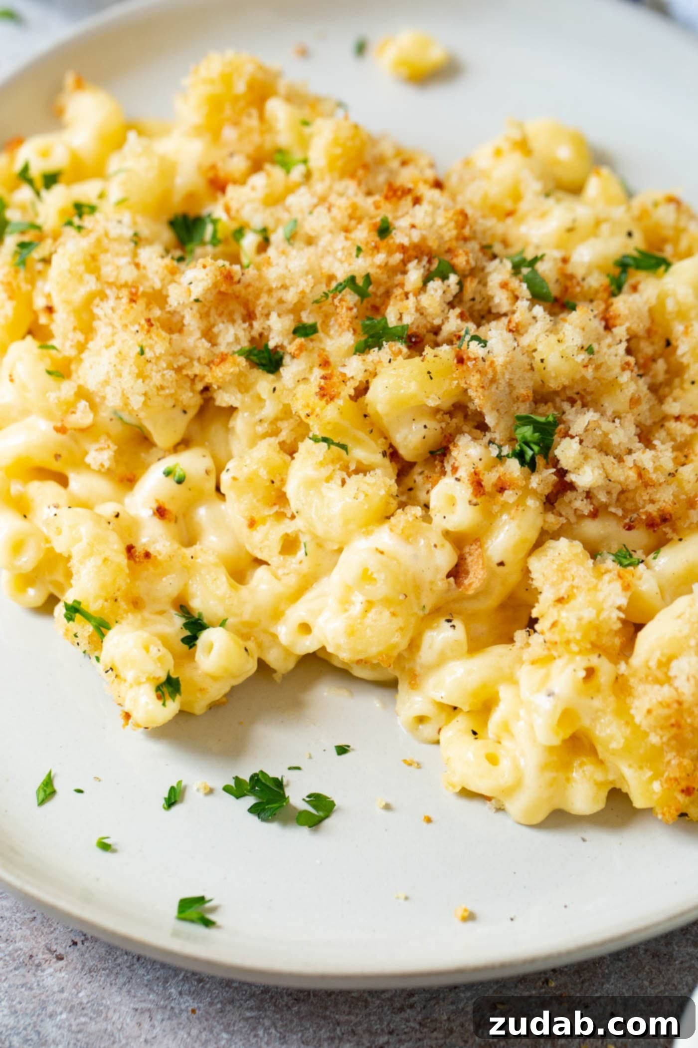 Best Macaroni and Cheese Ever Easy homemade macaroni and cheese served on a dinner plate, generously topped with browned bread crumbs.