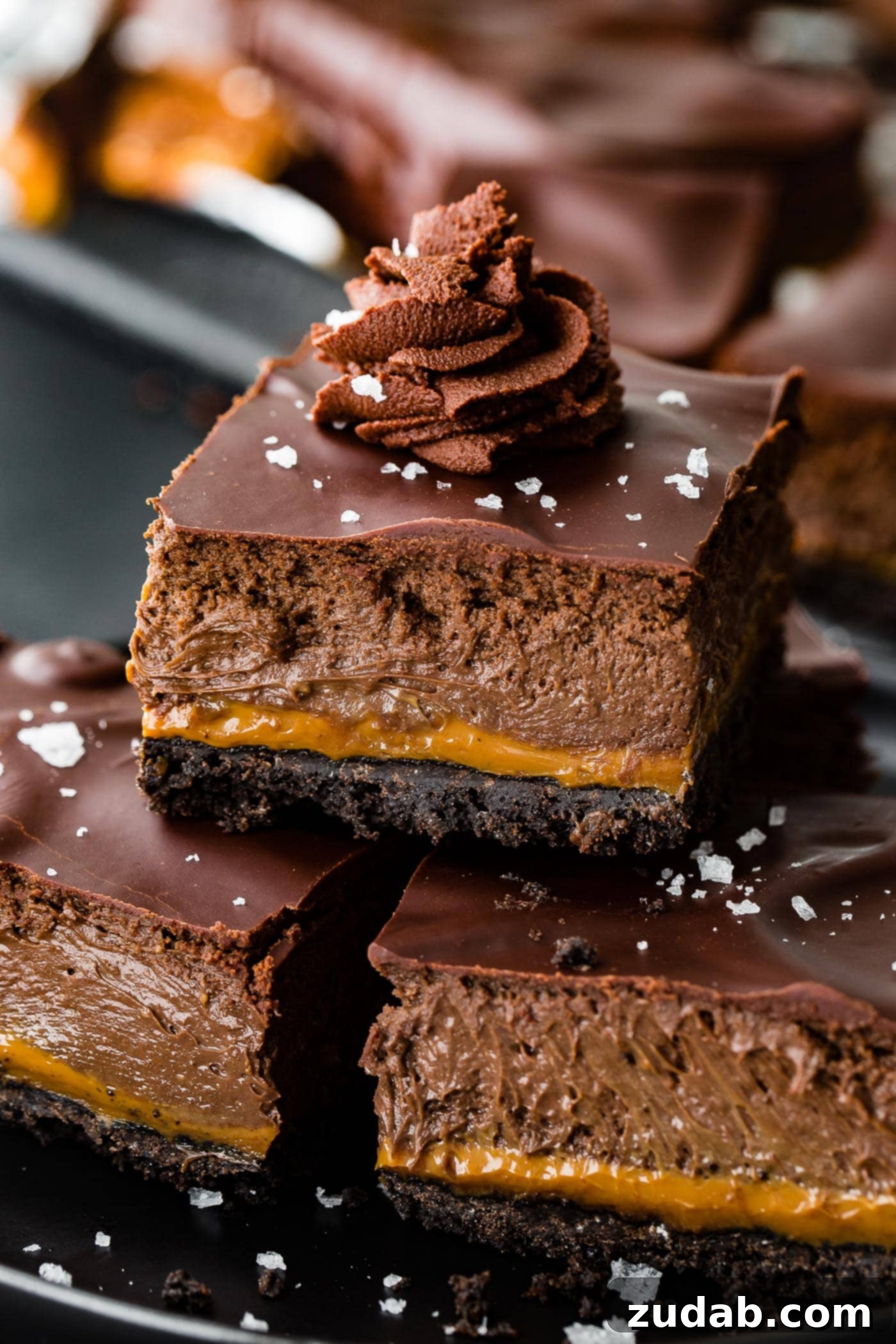 Decadent Dulce de Leche Chocolate Cheesecake Squares 8 a trio of layered gooey cream cheese dessert bar with whipped ganache and sea salt on top