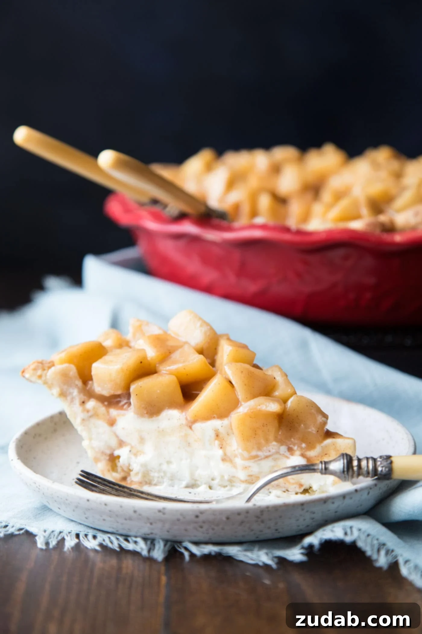 Creamy Apple Pie 2 A slice of apple cream pie on a plate, showcasing its creamy filling and apple topping.