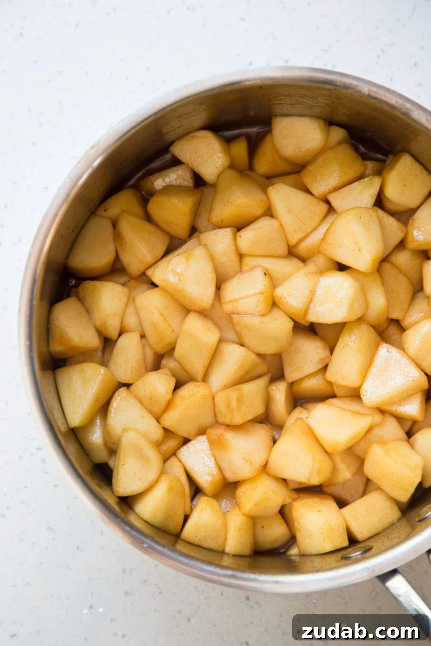 Creamy Apple Pie 3 Cooking diced apple for apple cream pie in a saucepan.