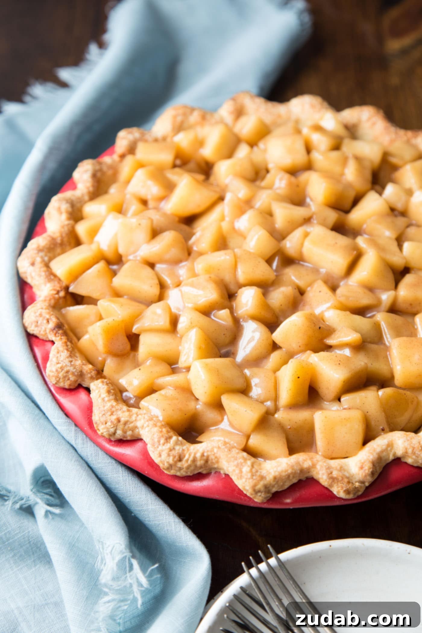 Creamy Apple Pie 5 An assembled apple cream pie in a vibrant red pie dish, ready for serving.