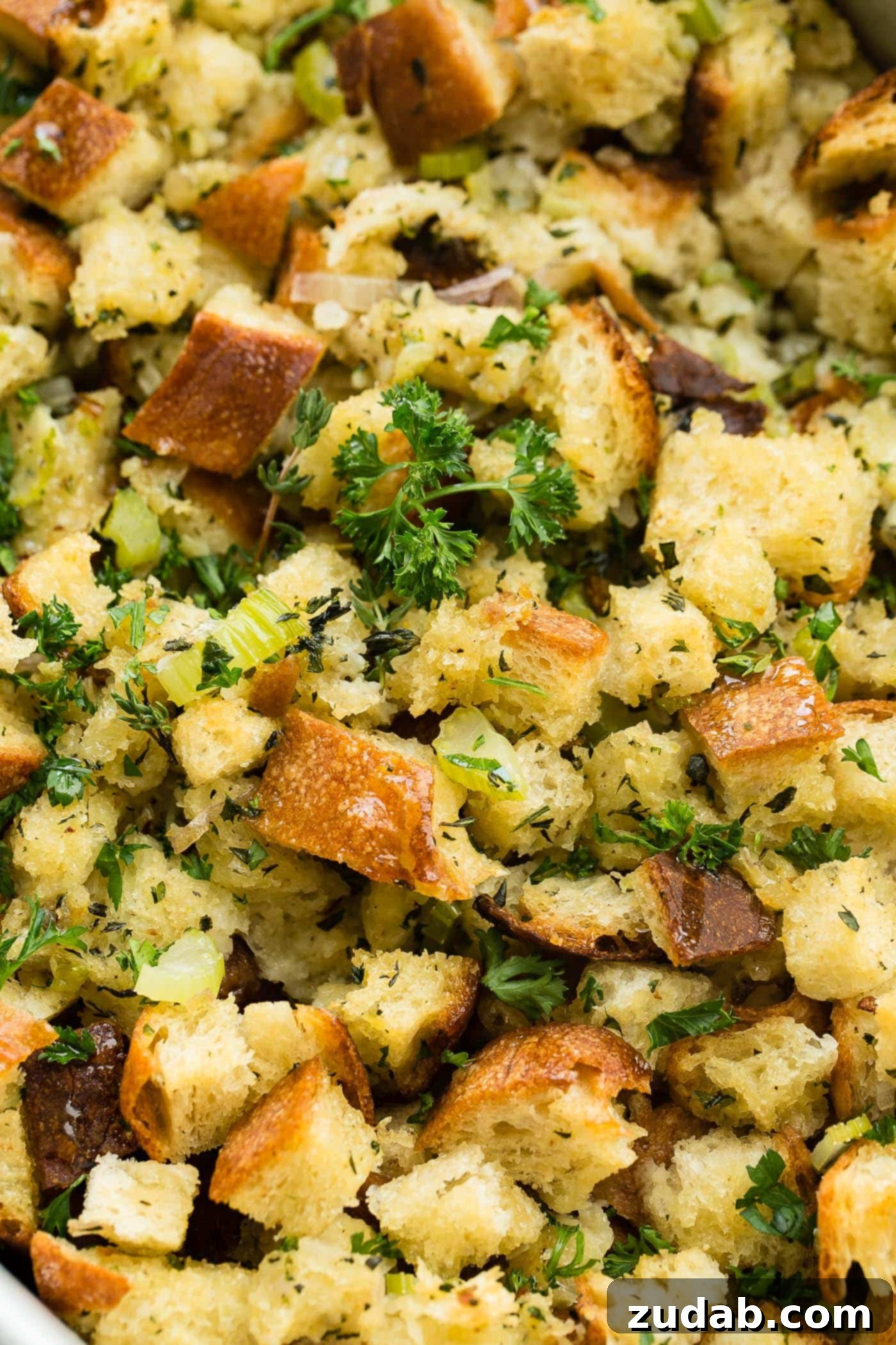 Make Ahead No Fuss Stuffing A close up photo of classic stuffing that is golden brown and topped with chopped fresh parsley.