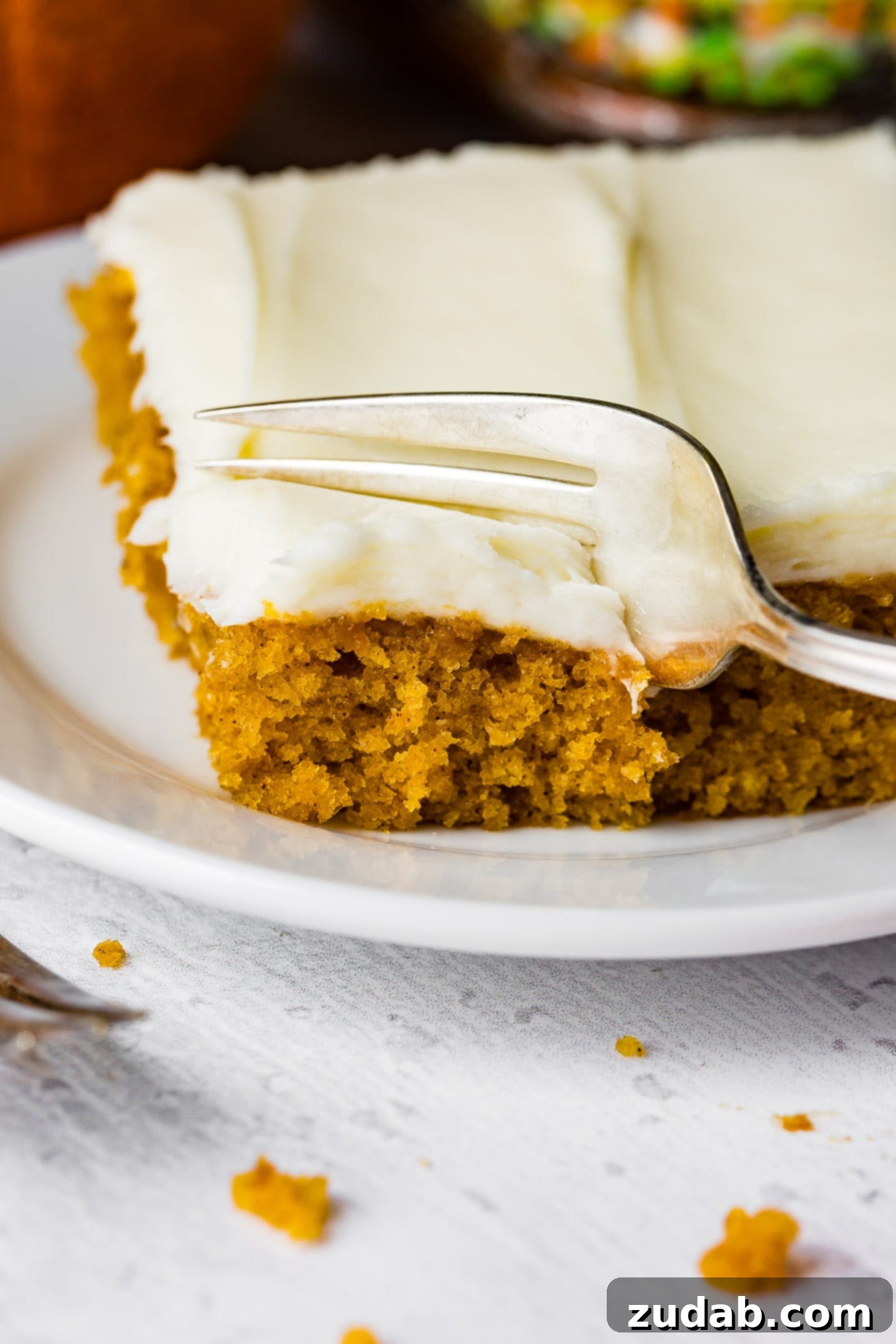Pumpkin Sheet Cake A photo of someone removing a bite of pumpkin sheet cake with a fork.