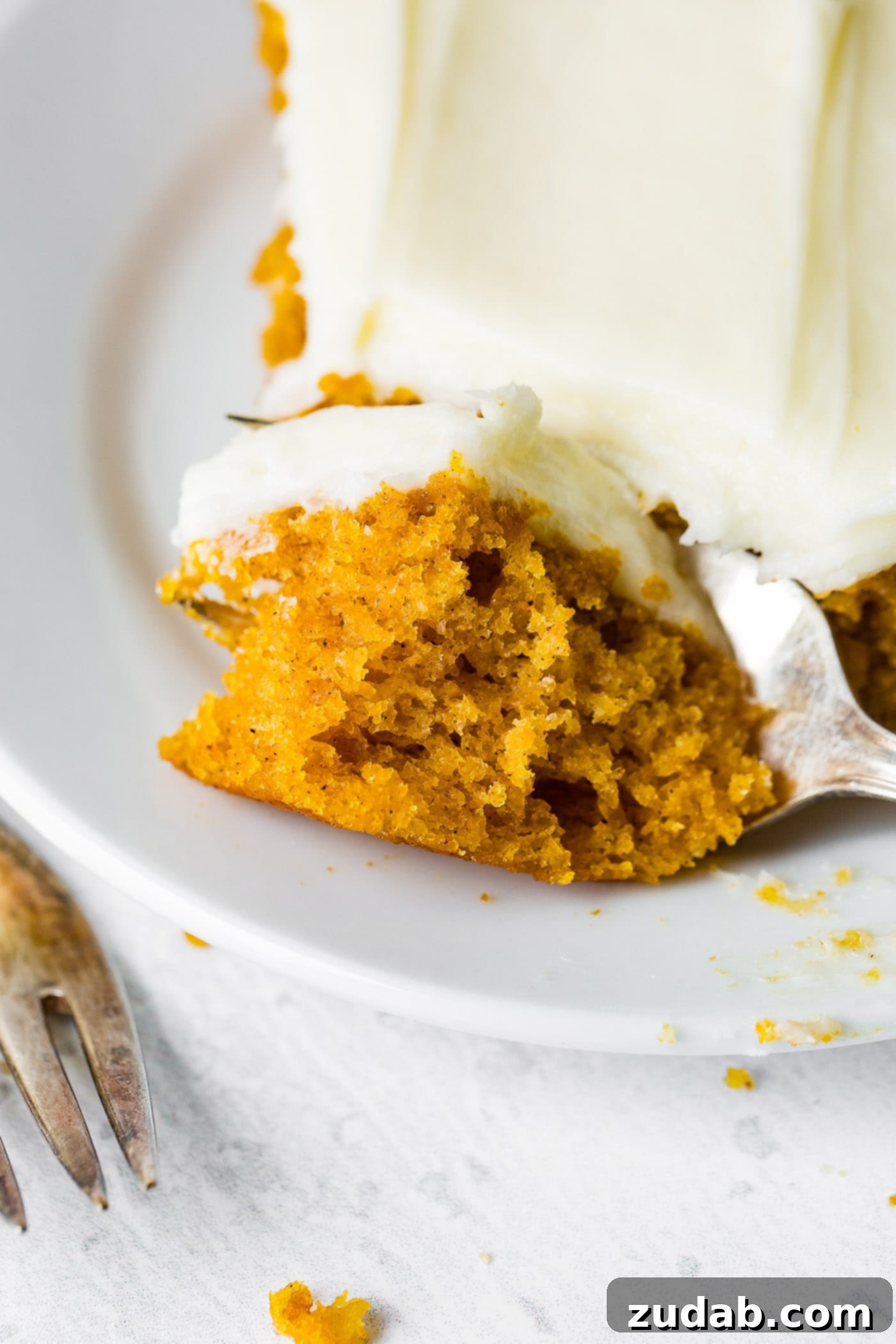 Pumpkin Sheet Cake A photo of someone removing a bite of pumpkin sheet cake with a fork.
