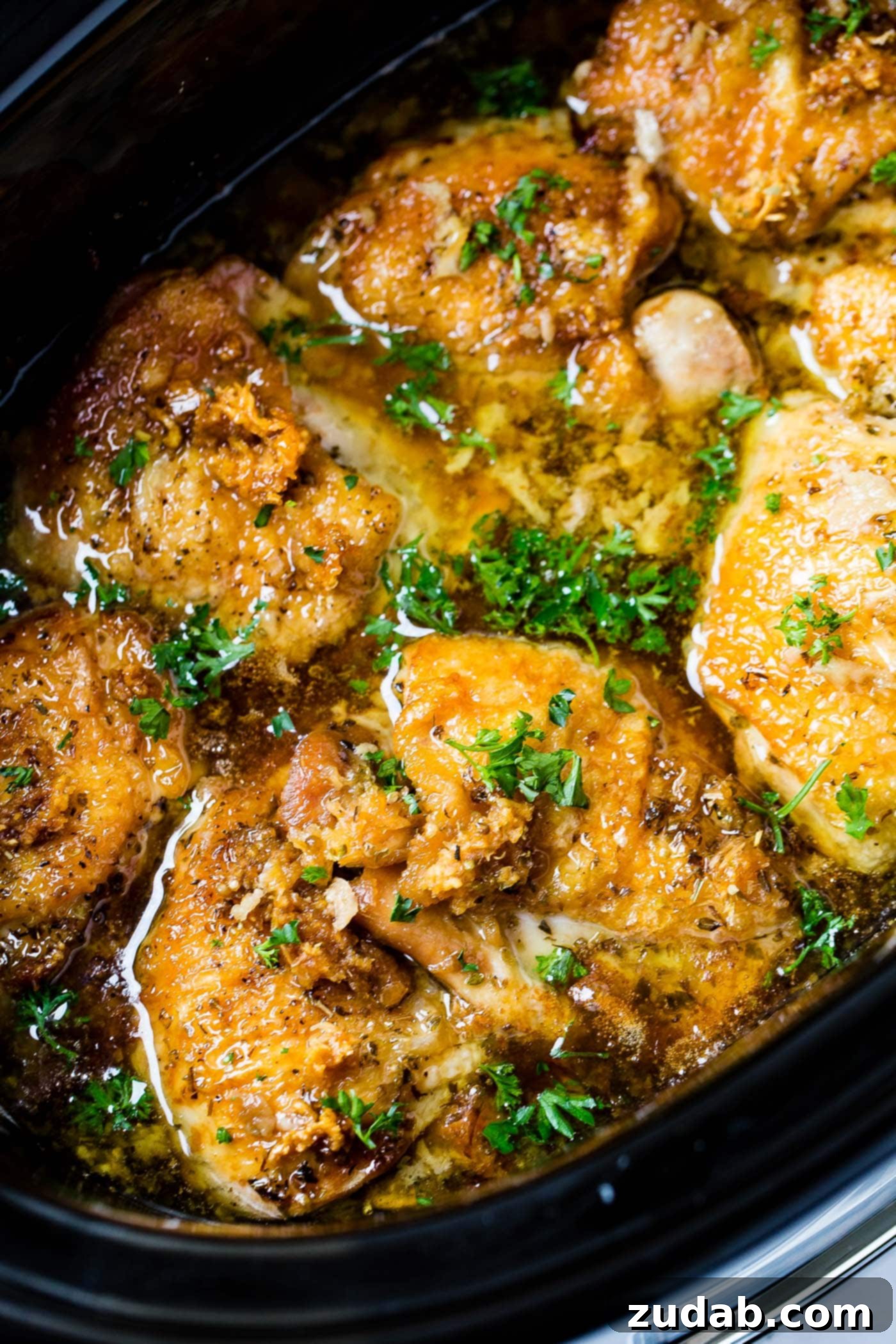 A photo of delectable Slow Cooker Garlic Chicken simmering in a crock pot, ready to be served.