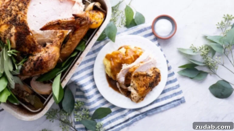 The Ultimate Golden Oven Roasted Thanksgiving Turkey 2 a photo of a whole roasted turkey with one breast cut off and sitting on a plate next to the roasting pan