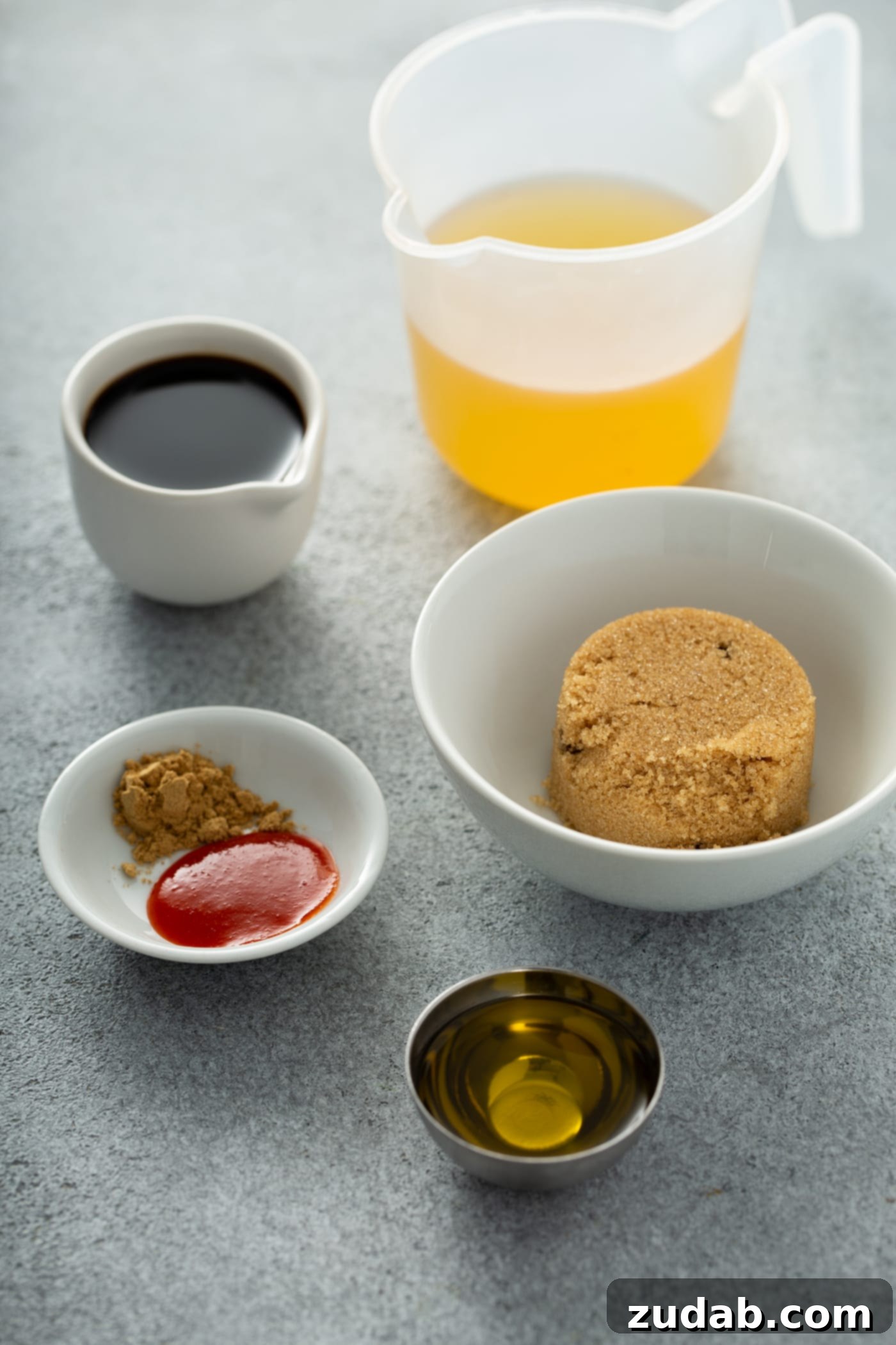 Instant Pot Beef and Broccoli A photo of all the ingredients in separate dishes to make the sauce for beef and broccoli, including beef broth, soy sauce, brown sugar, ground ginger, sriracha sauce, and sesame oil.