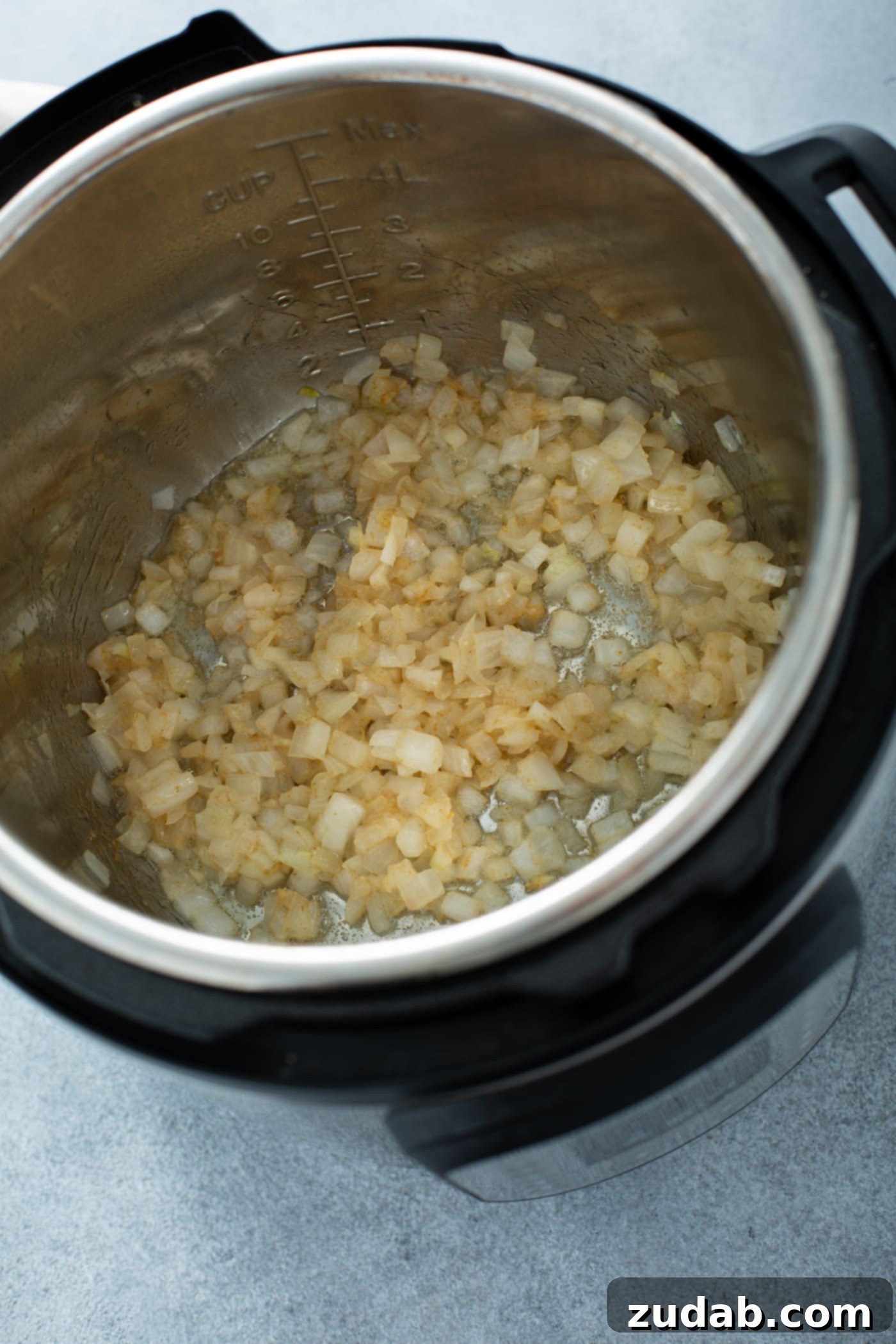 Instant Pot Beef and Broccoli A photo of chopped onions being sauteed in an Instant Pot.