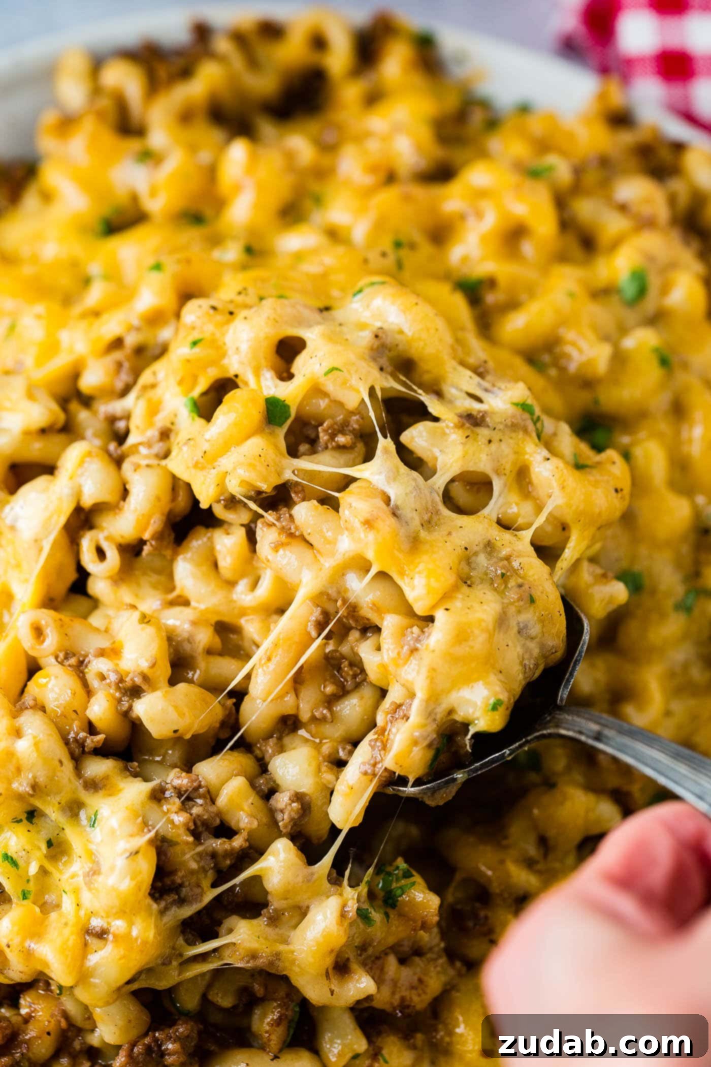 Instant Pot Hamburger Helper A photo of a serving of Instant Pot Hamburger Helper being spooned out of a dish, highlighting its creamy texture and rich color.
