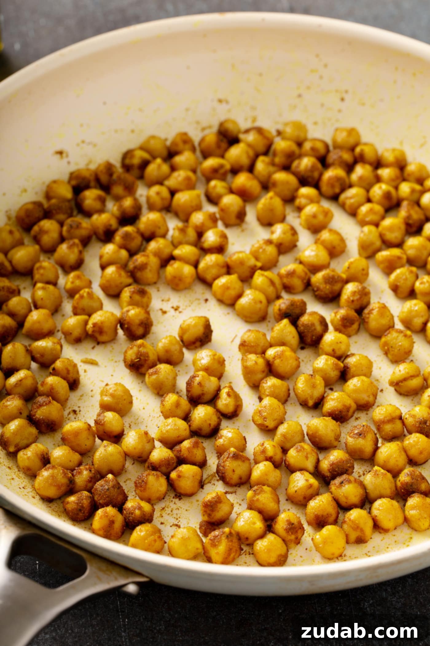 Wild Rice and Chickpeas with Crispy Shallots A photo of spiced chickpeas being roasted in a pan.
