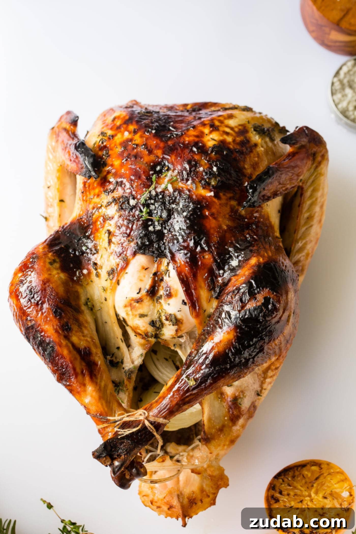 How to Carve a Turkey A roasted whole turkey, golden brown and ready for carving, resting on a cutting board with herbs.