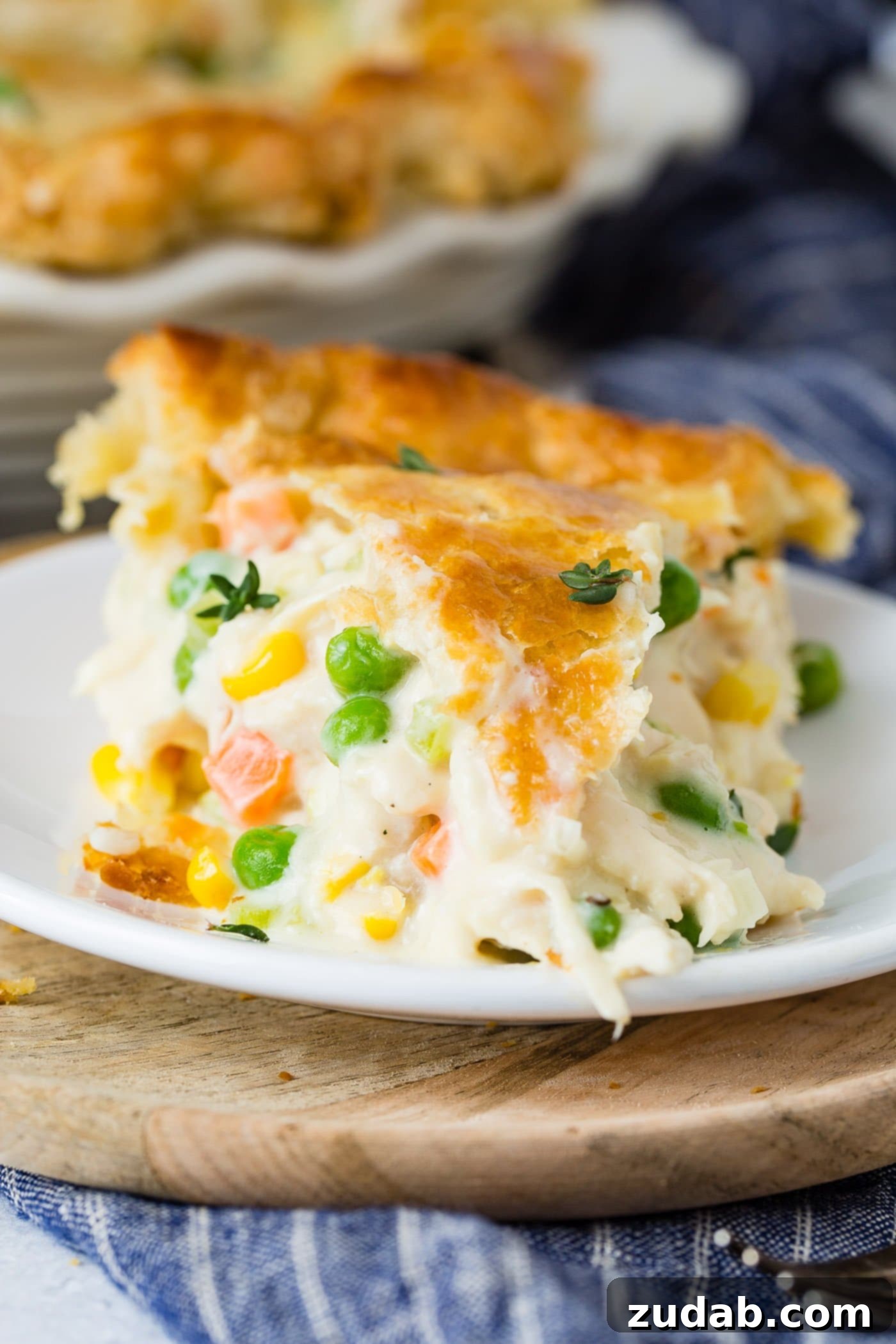 My Best Homemade Chicken Pot Pie Recipe A close-up of a slice of chicken pot pie filled with chicken, carrots and peas.