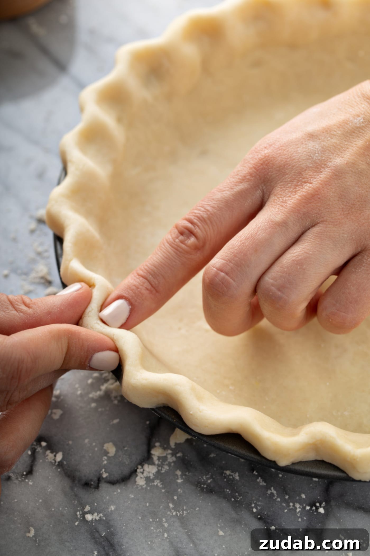 Master My Absolute Favorite Pie Crust With This Video 10 A photo of the edges of an uncooked pie crust being crimped.