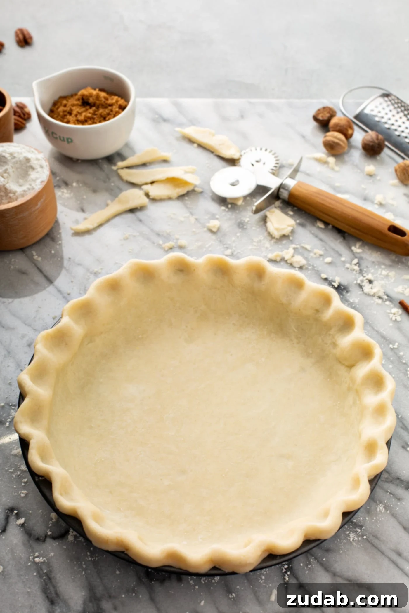 My Absolute FAVORITE Pie Crust Recipe A photo of an uncooked pie crust in a pie tin sitting on a table