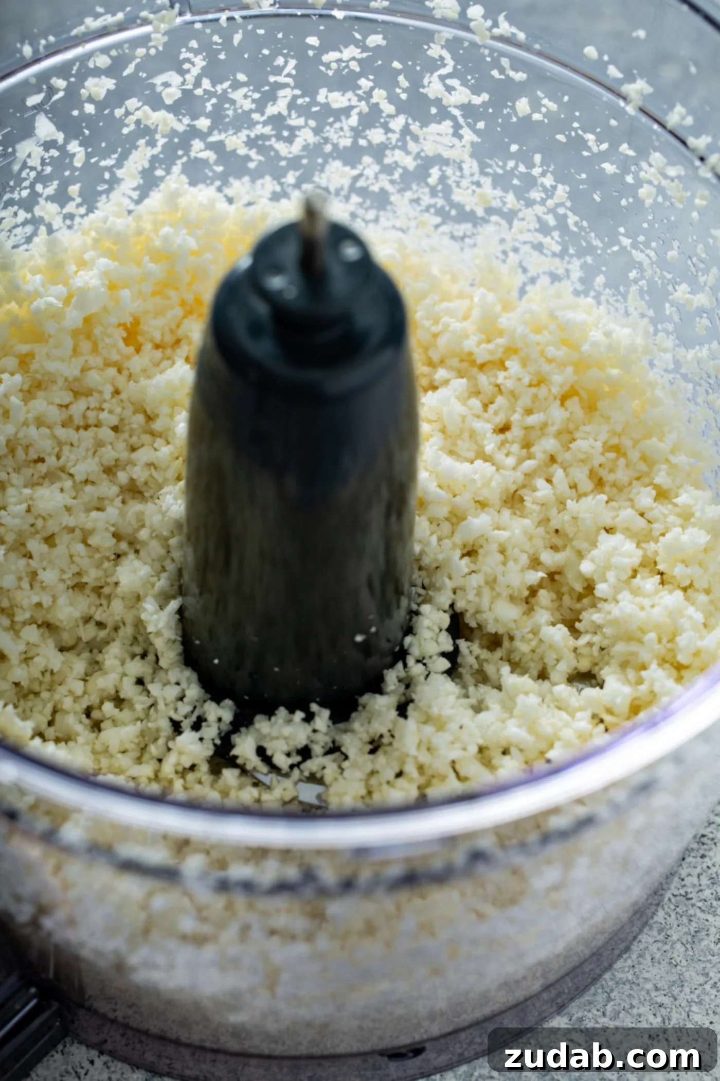 Homemade Cauliflower Rice with a Food Processor A food processor containing chopped cauliflower, ready to be processed into rice.
