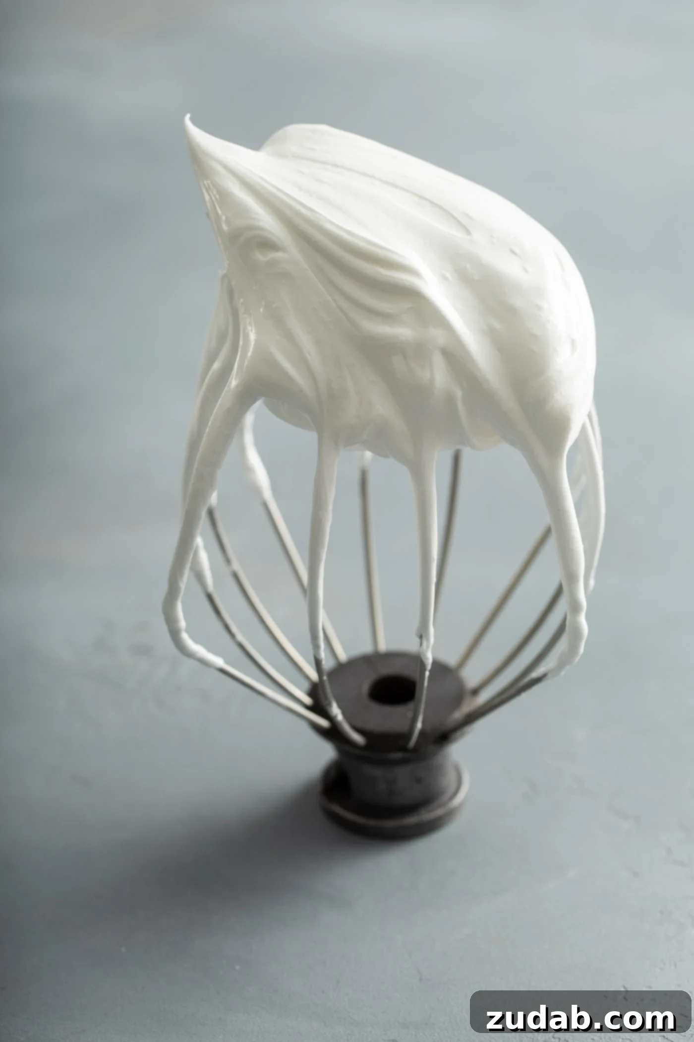 A beater from a stand mixer with firm meringue on the end.
