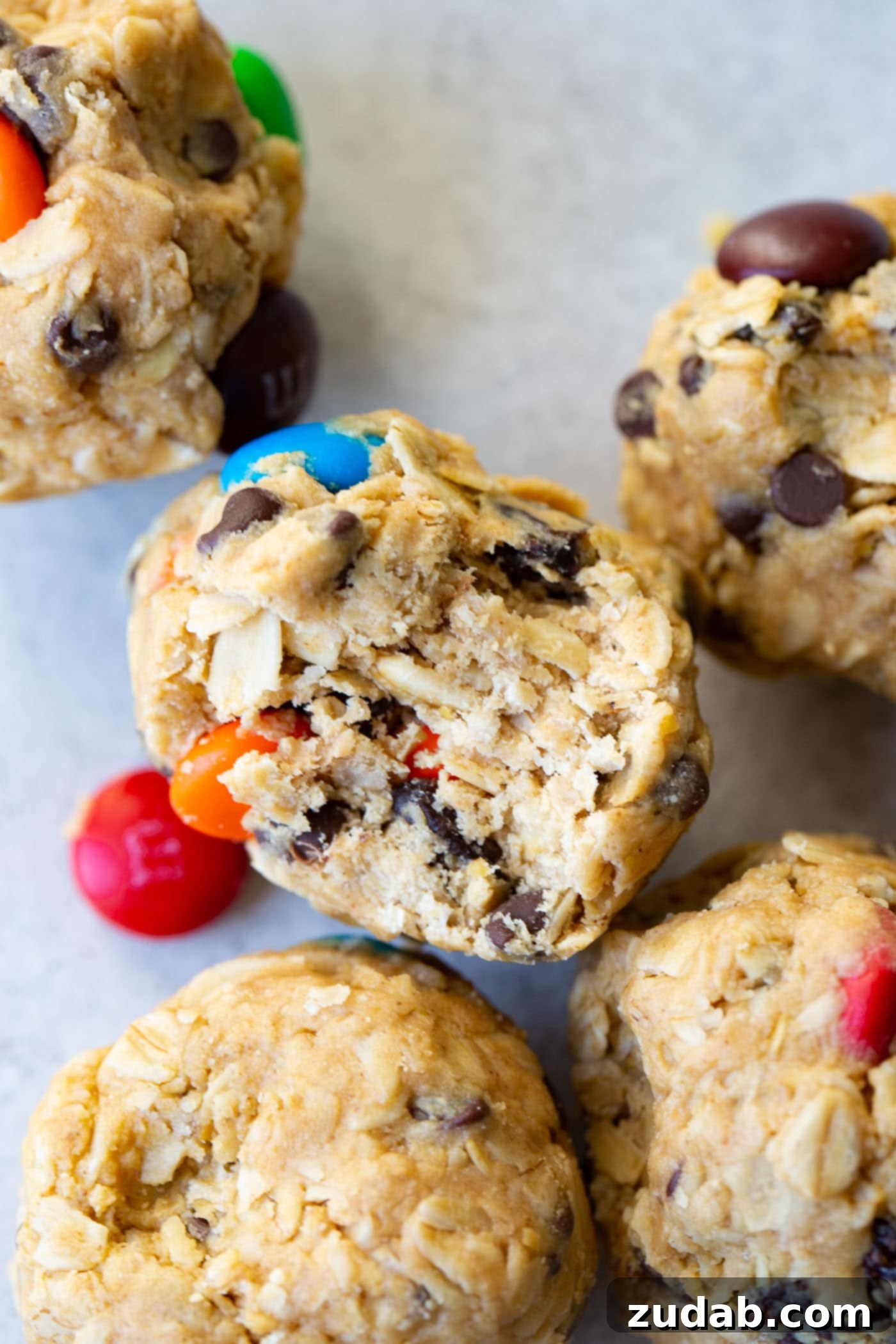 Loaded Peanut Butter Protein Bites 5 A delicious bite taken from a monster cookie peanut butter protein ball, revealing its rich texture and colorful mix-ins.