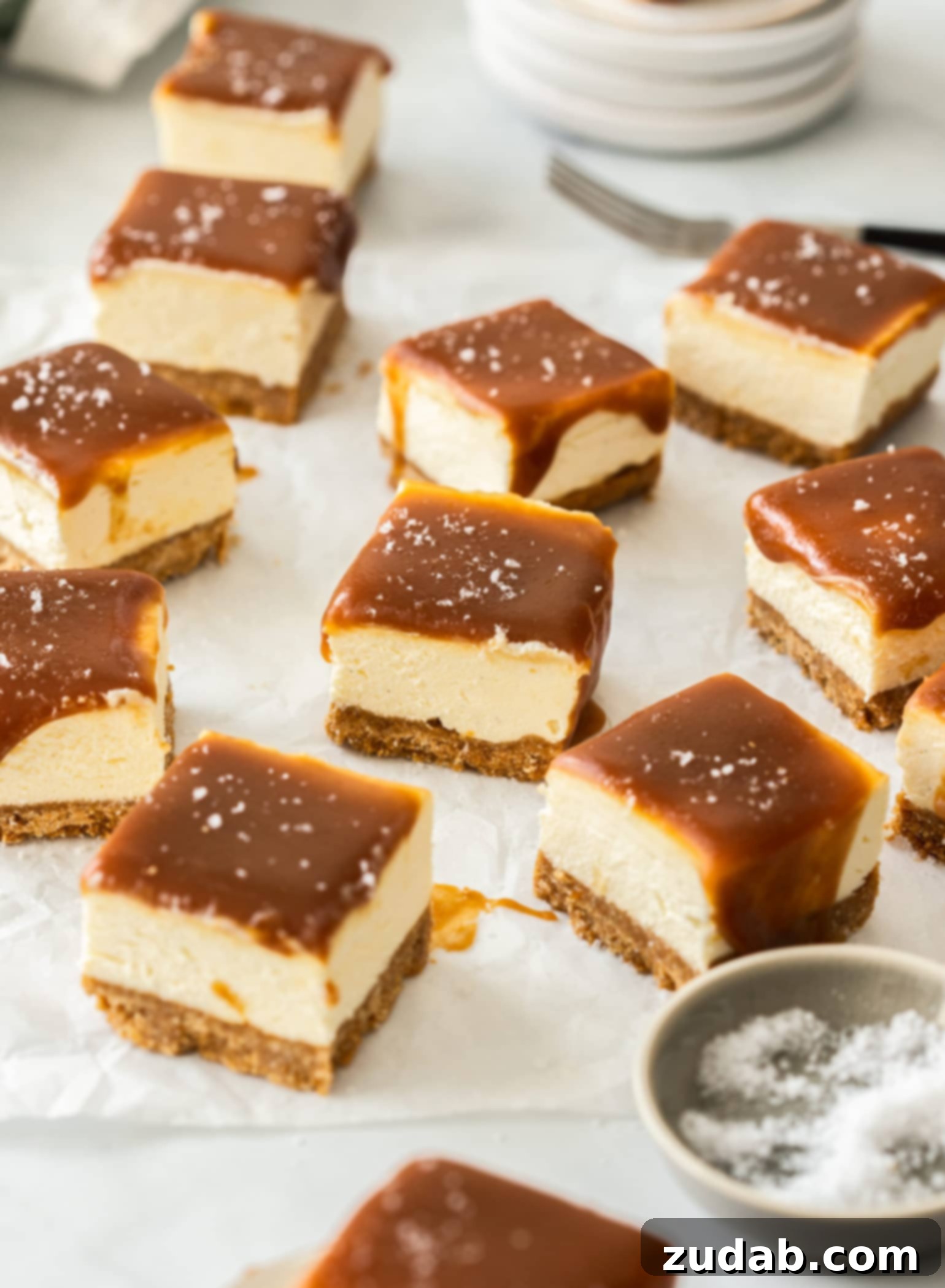 Effortless Caramel Bliss Bars 2 A batch of 10 golden caramel cheesecake bars arranged neatly on a sheet of white baking paper